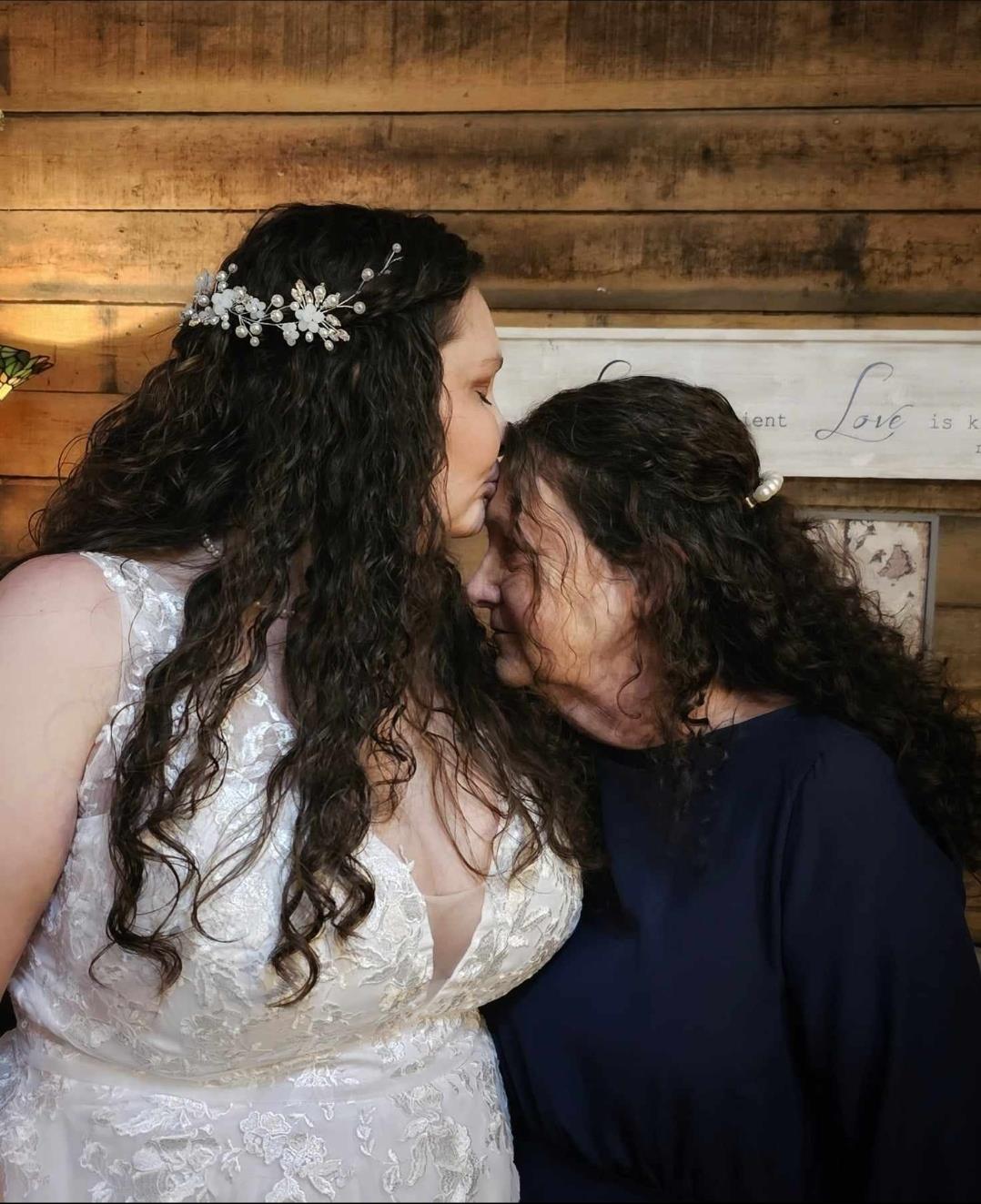 Two women in a wedding dress kissing