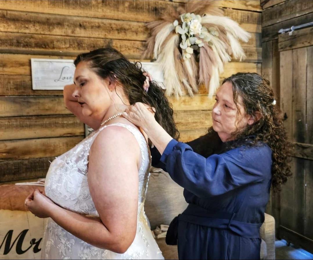 A woman helping another woman to put on a necklace