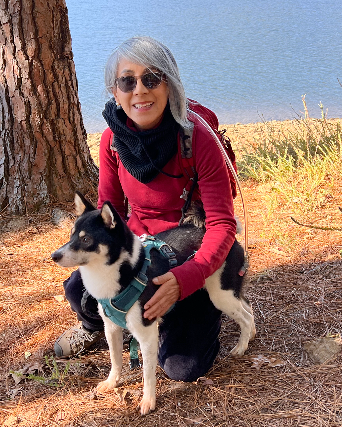 A woman kneeling on her lap with a dog