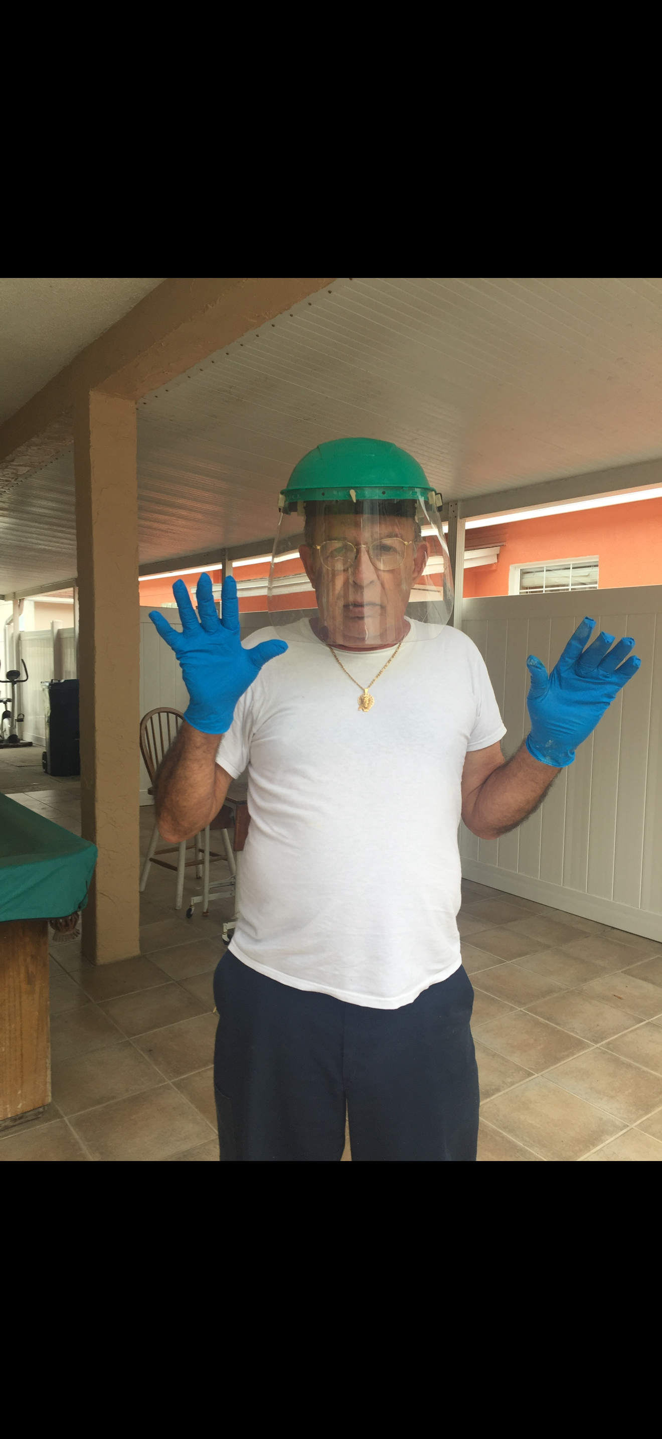 A man wearing a face shield and gloves