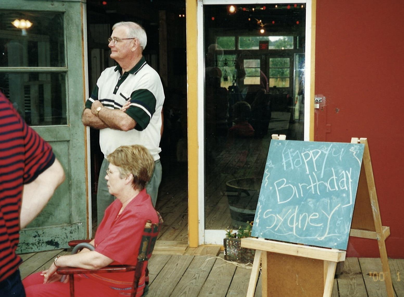 A man standing in front of a sign