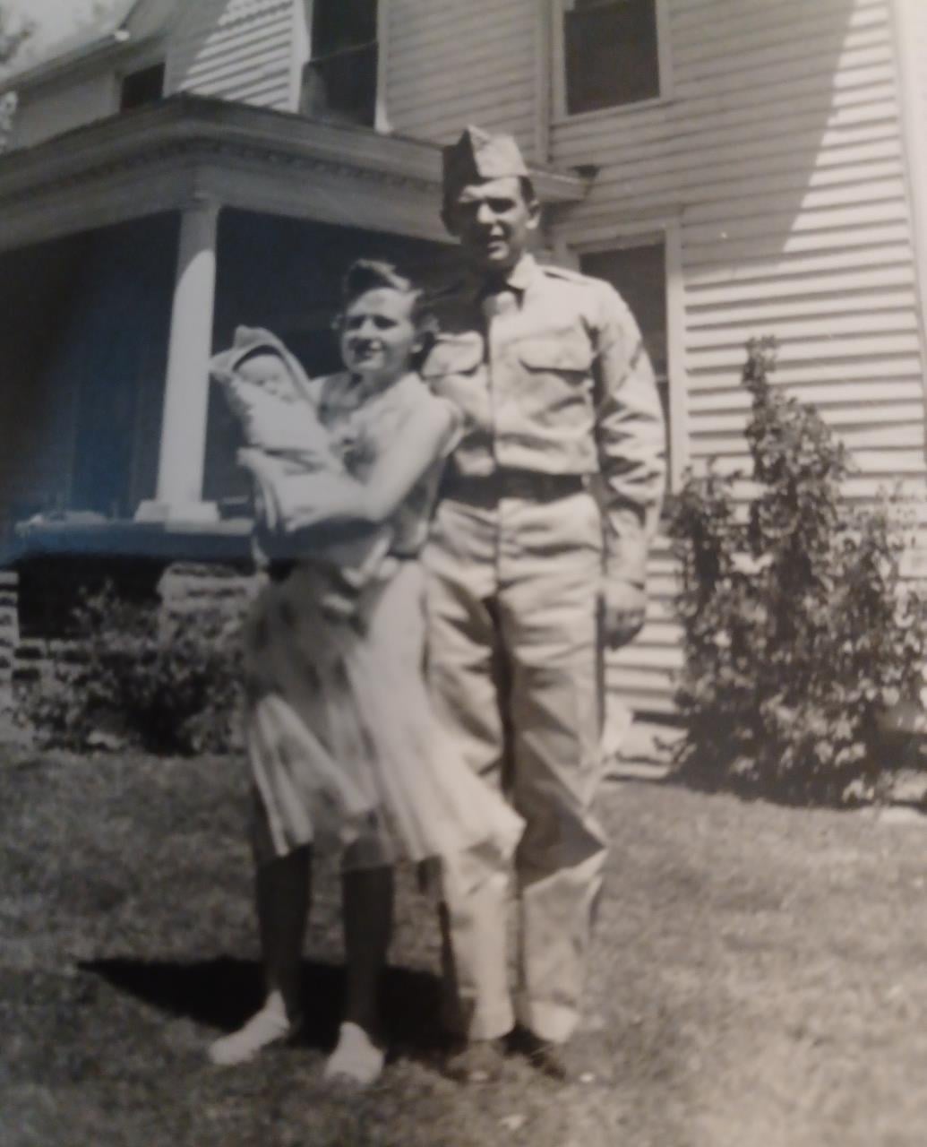 A man and woman standing in front of a house