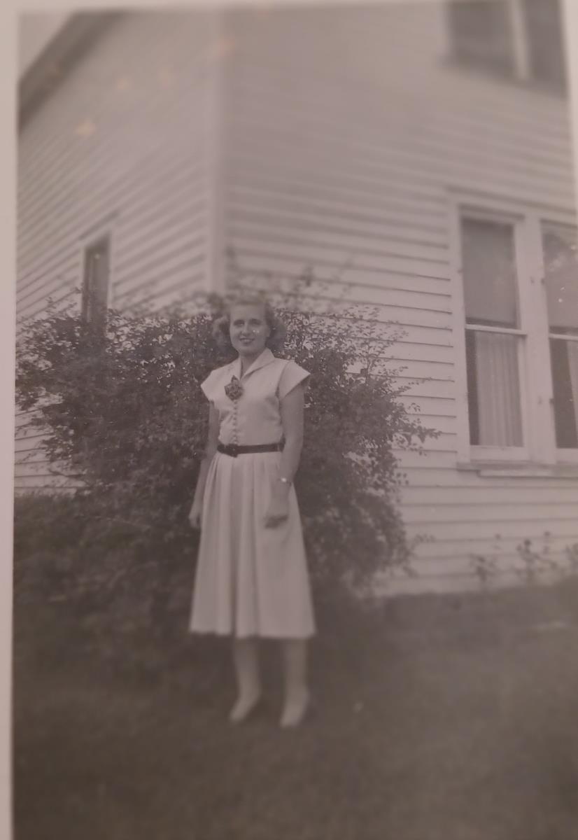 A woman standing in front of a house