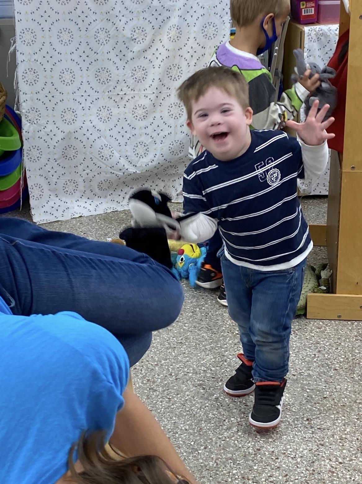 A boy with down syndrome playing with a person