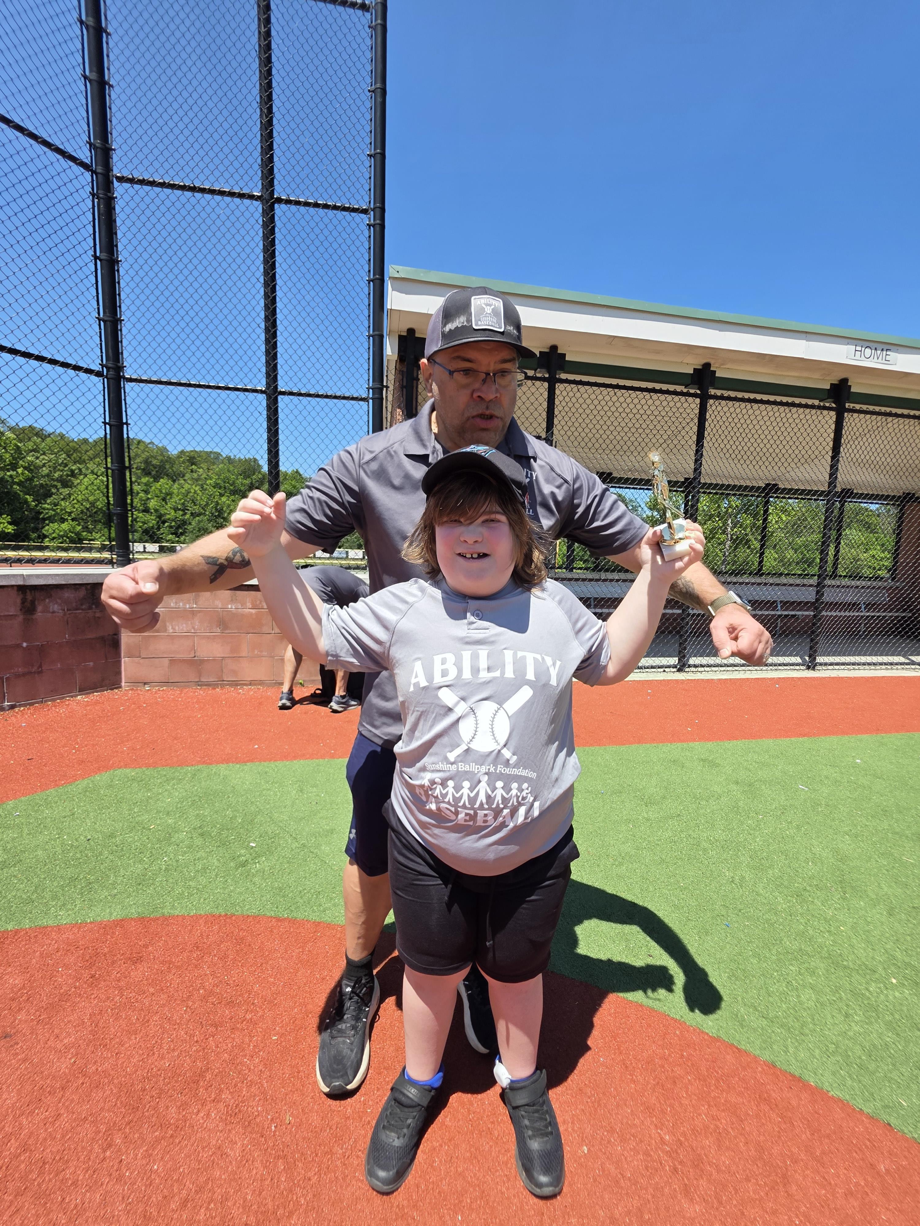 A man and boy standing on a baseball field
