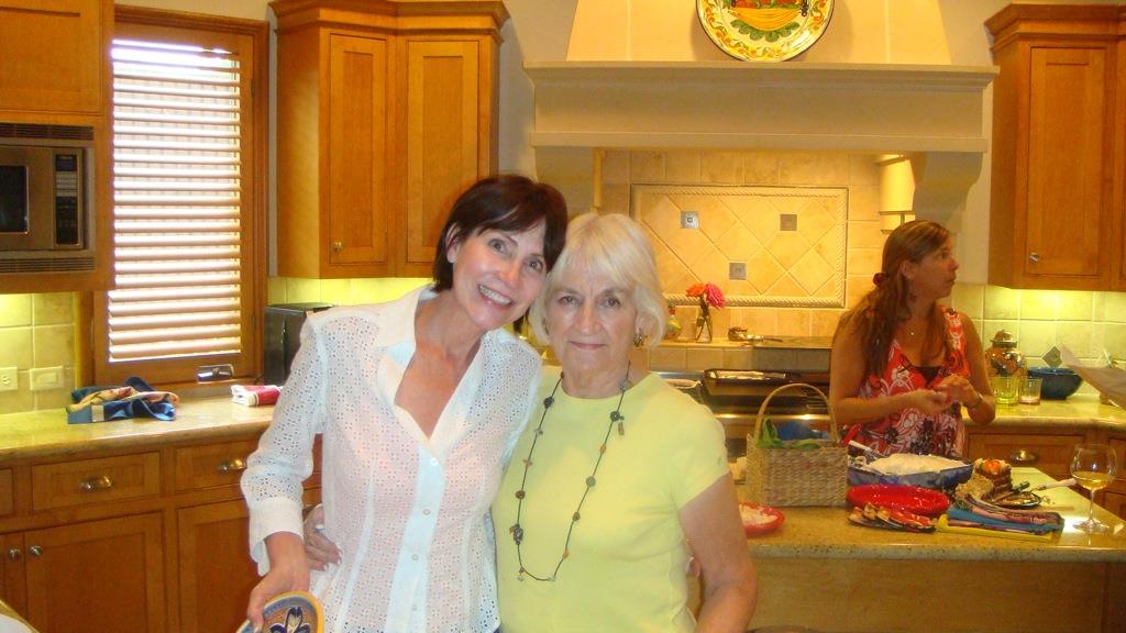 A woman standing next to another woman in a kitchen