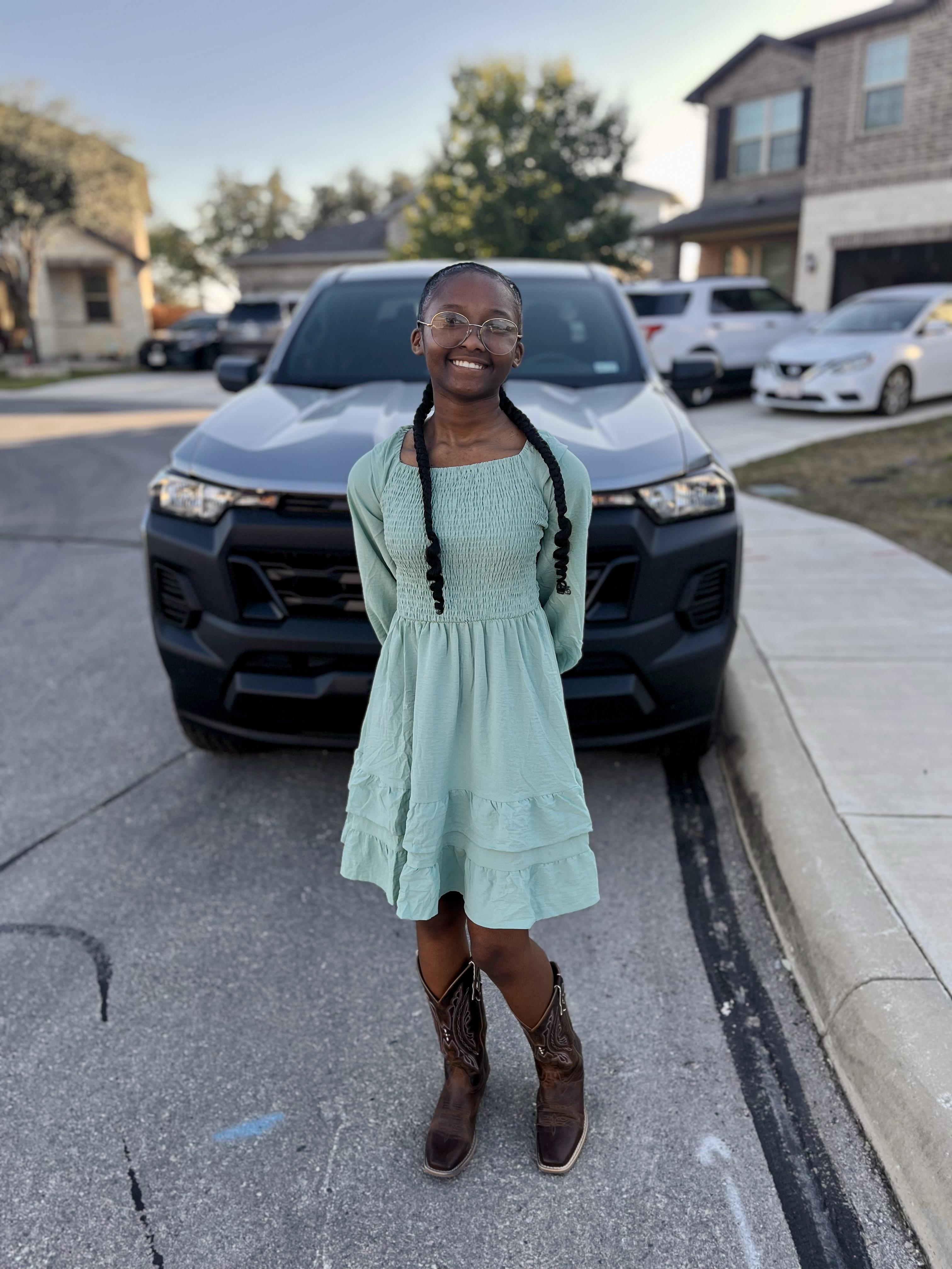 A girl standing in front of a car