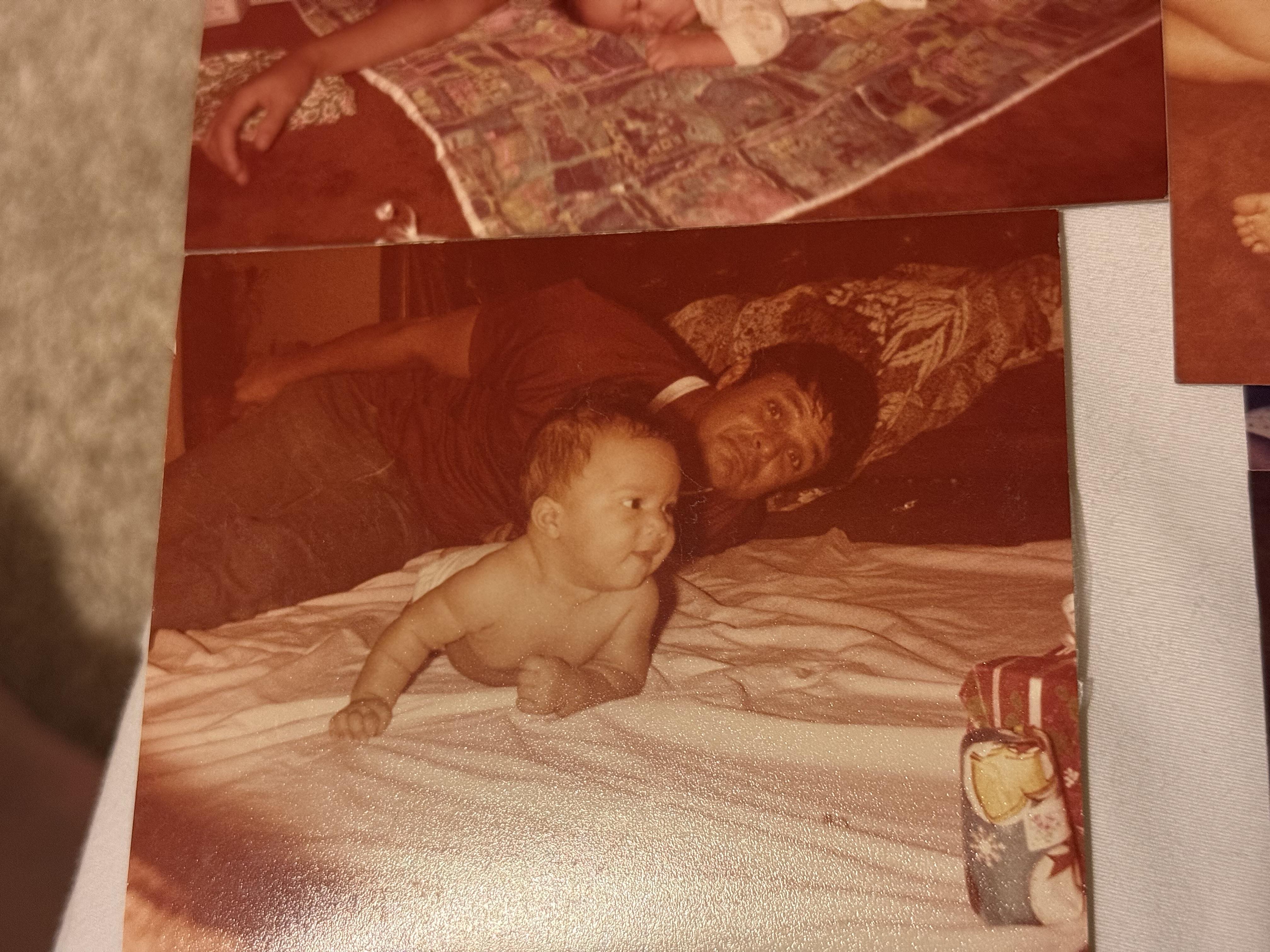 A black and white photo of a baby lying on a white blanket