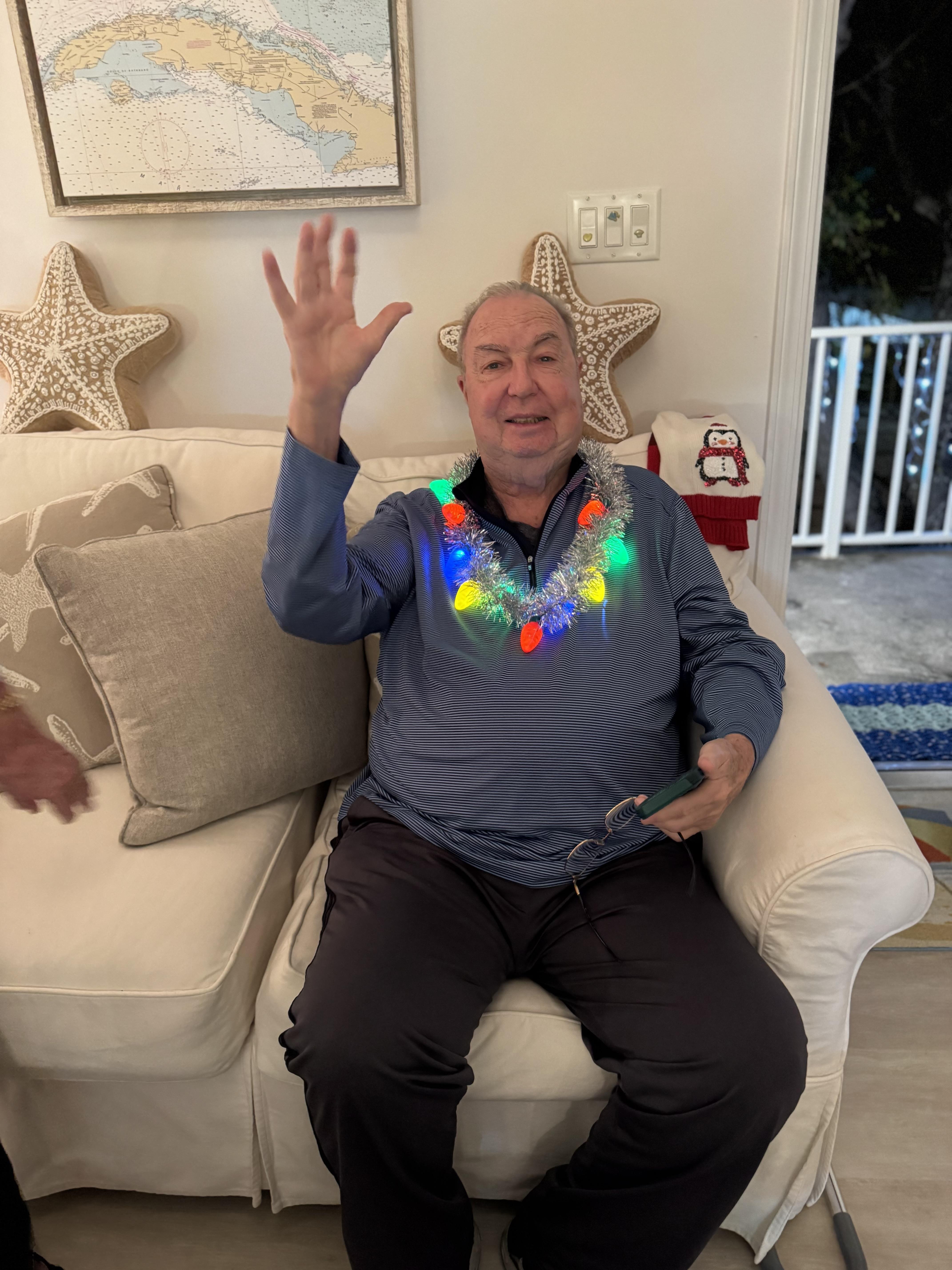 A man sitting on a couch waving