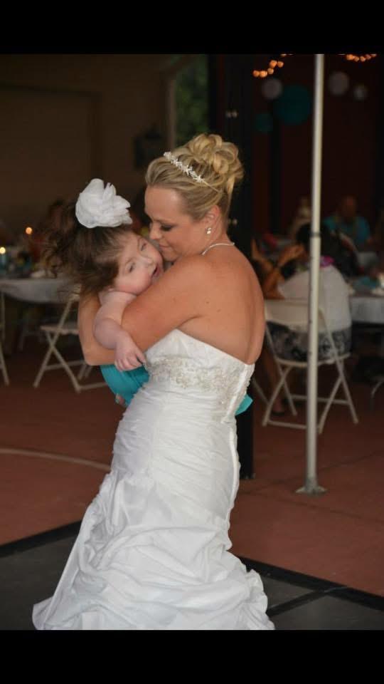 A woman in a wedding dress holding a baby