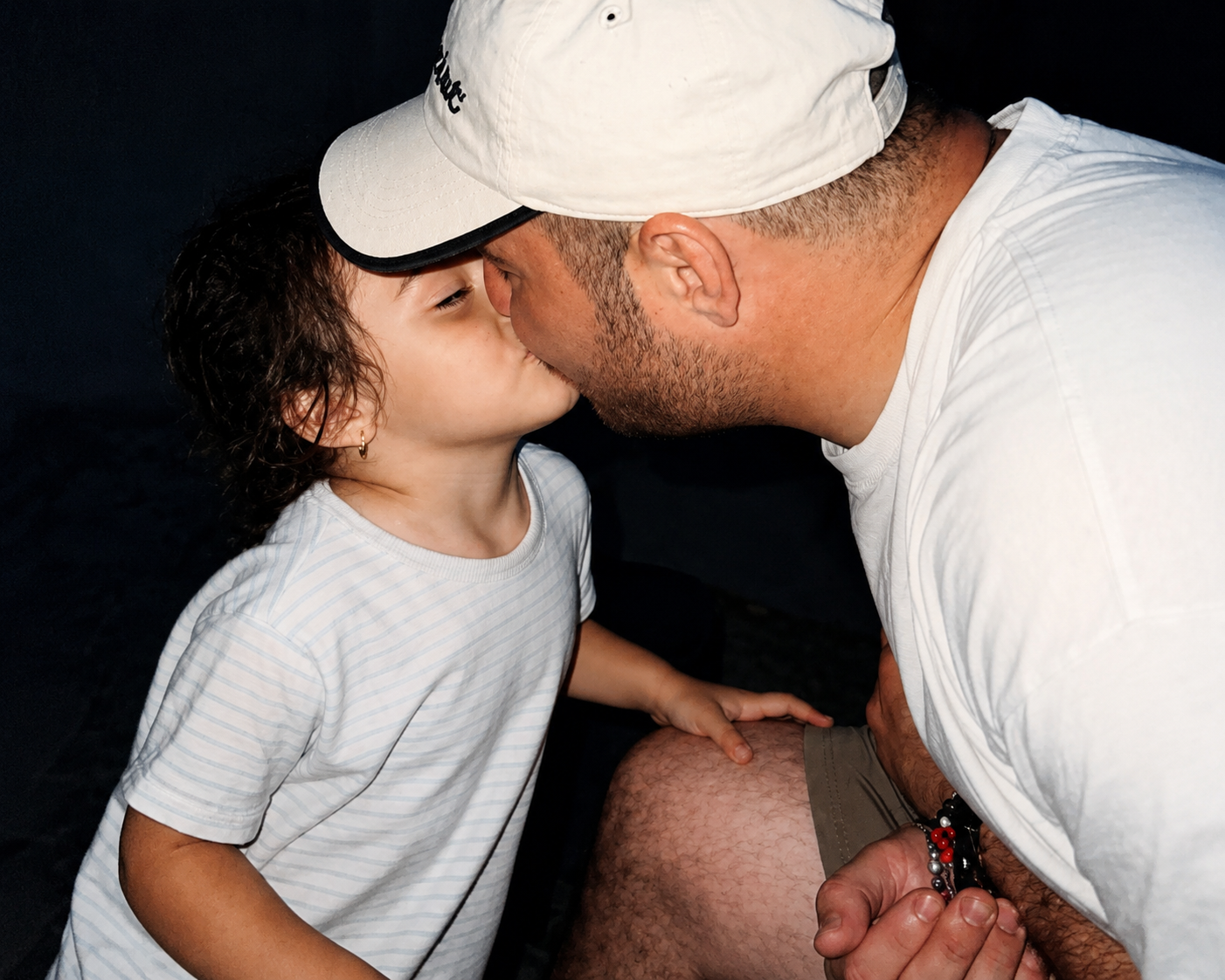 A man and child kissing