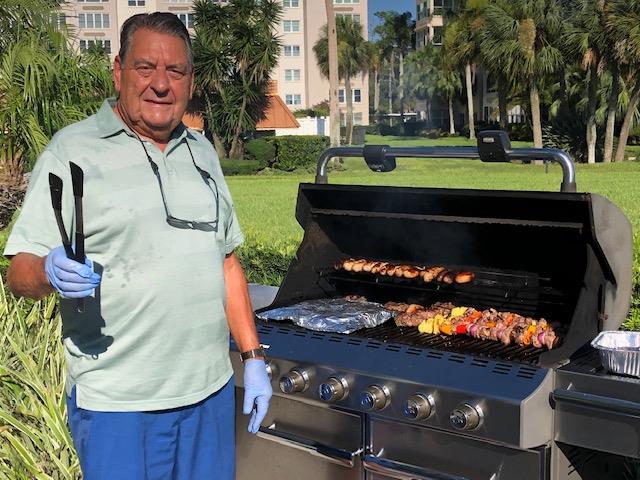 A man standing next to a grill