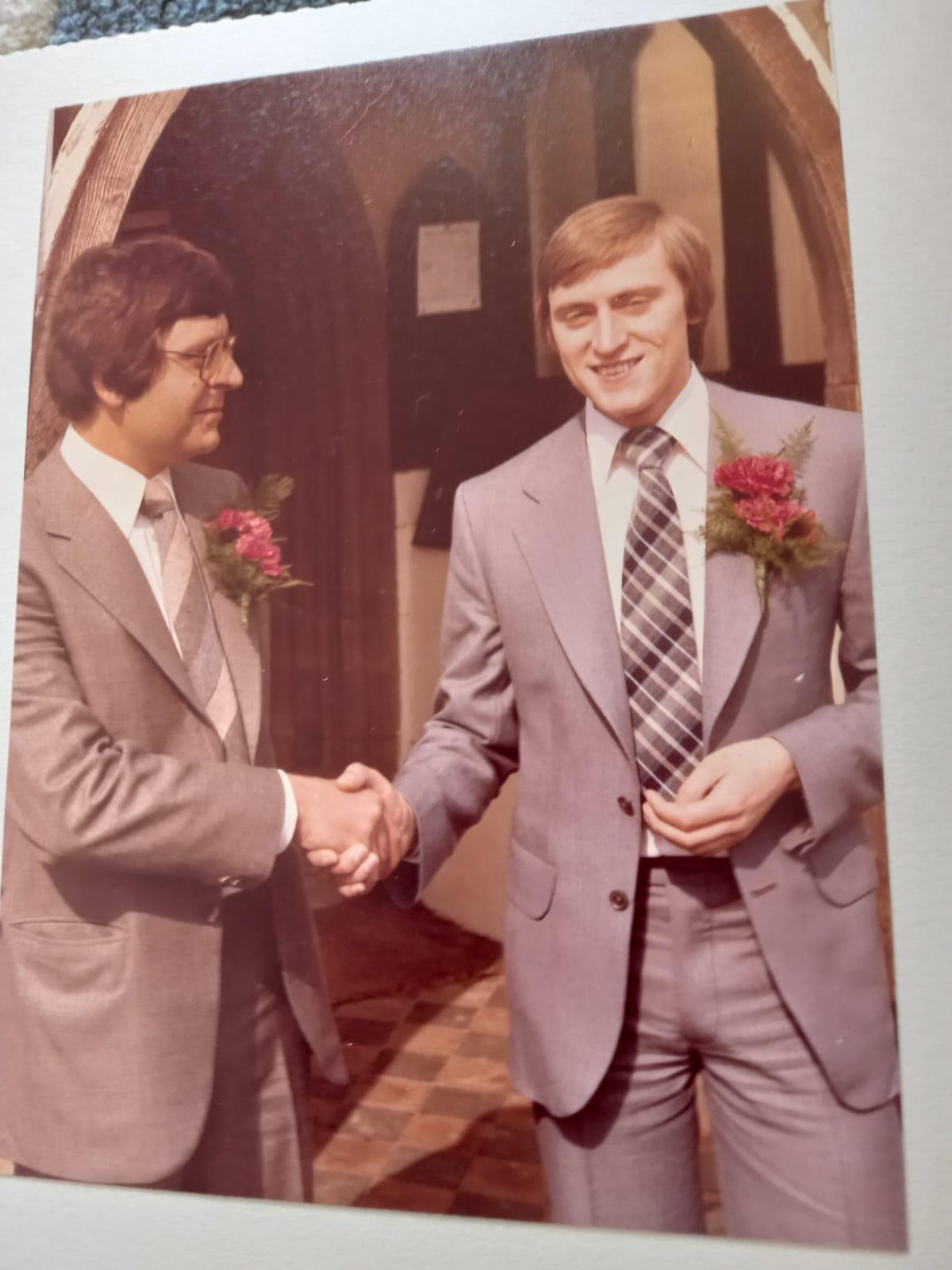 A man in a suit shaking hands with another man in a suit