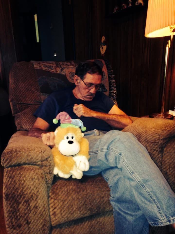A man sitting on a chair with a stuffed animal