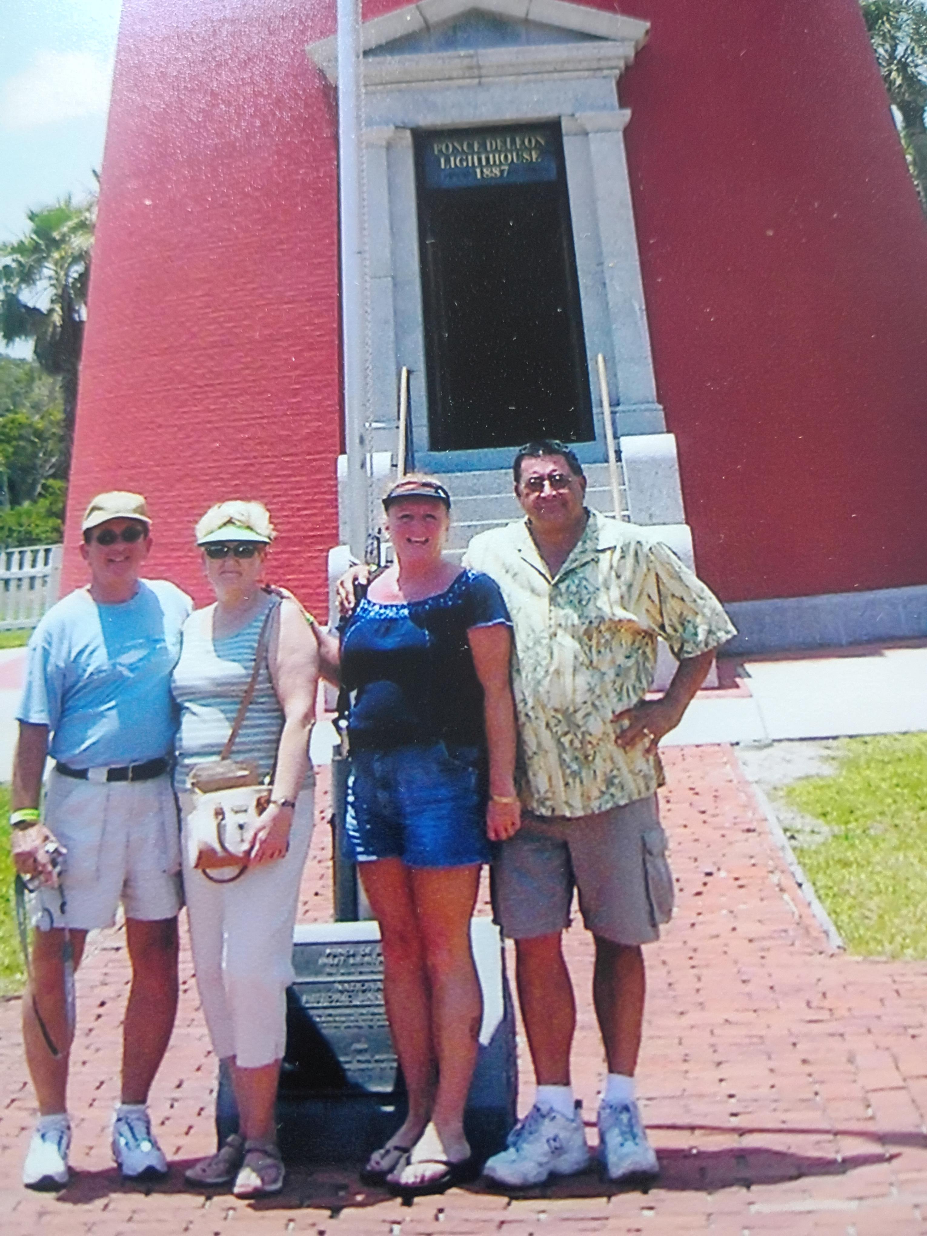 A group of people standing in front of a red building