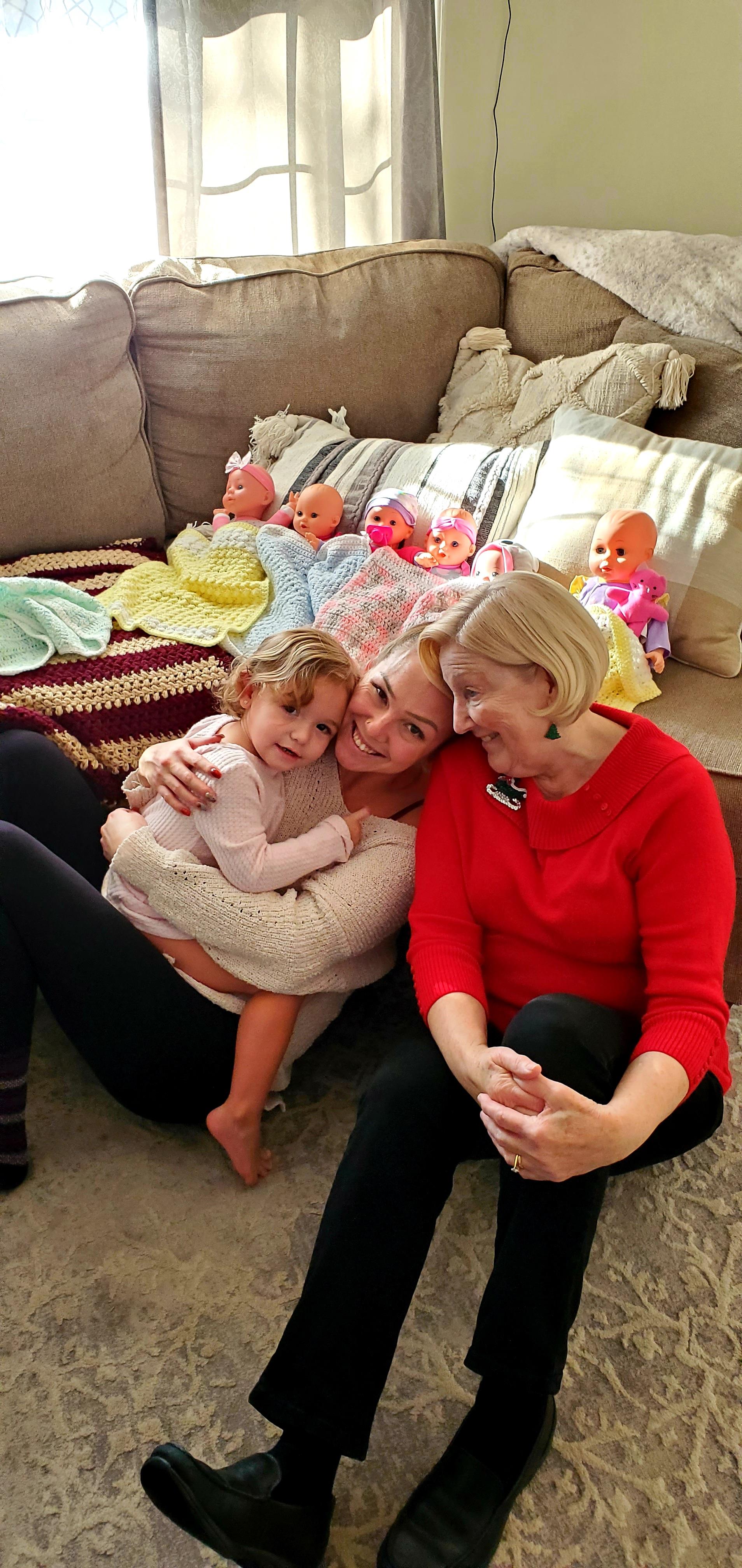 A group of women sitting on a couch with a baby
