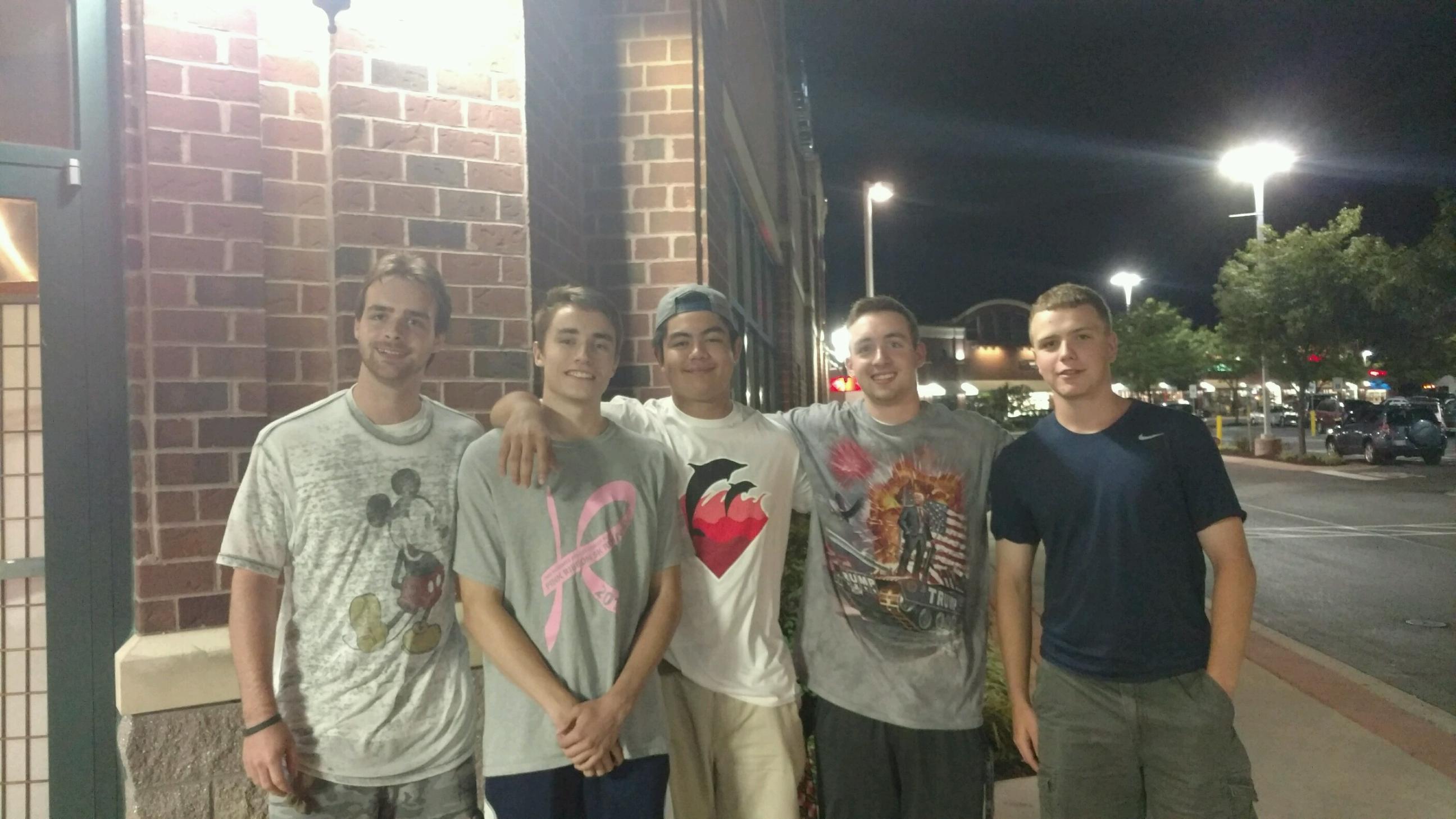 A group of young men standing together outside a building