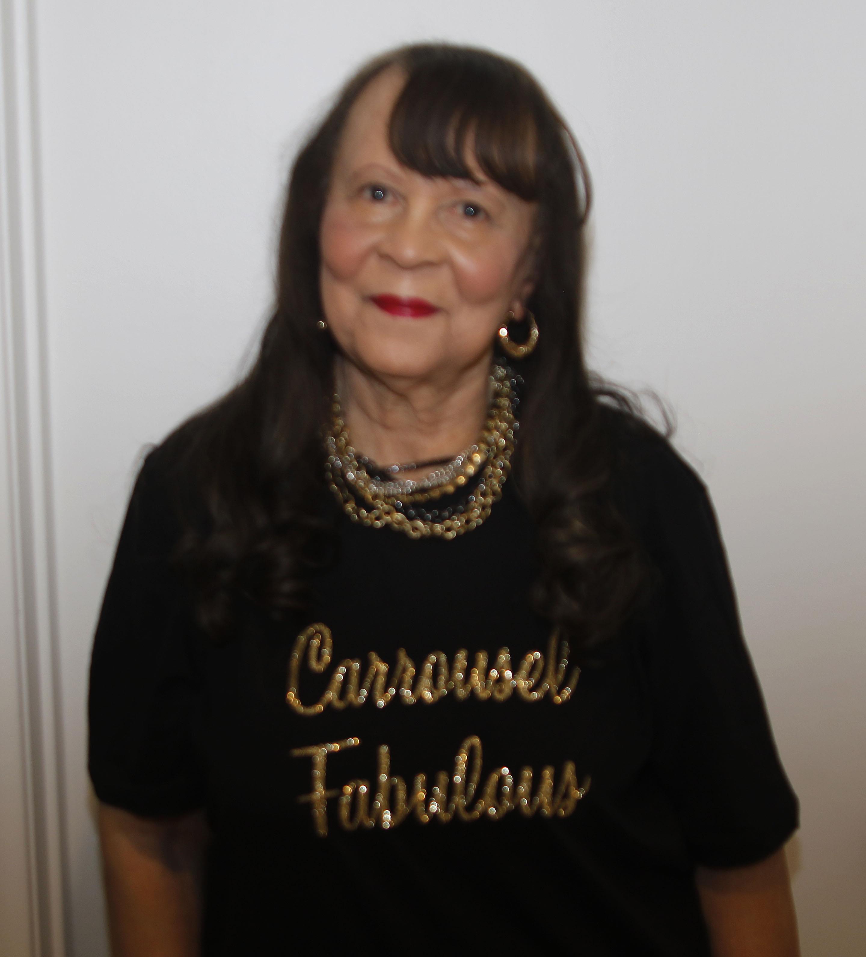 A woman wearing a black shirt with gold text