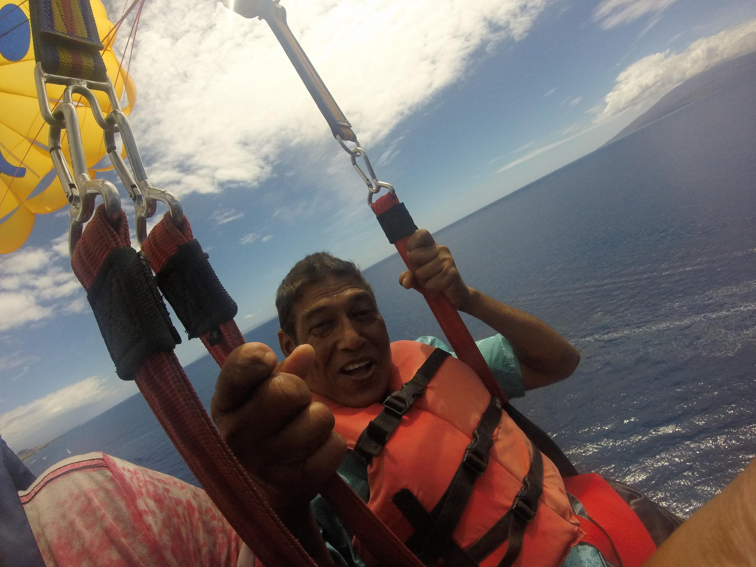 A man in a life jacket holding onto straps