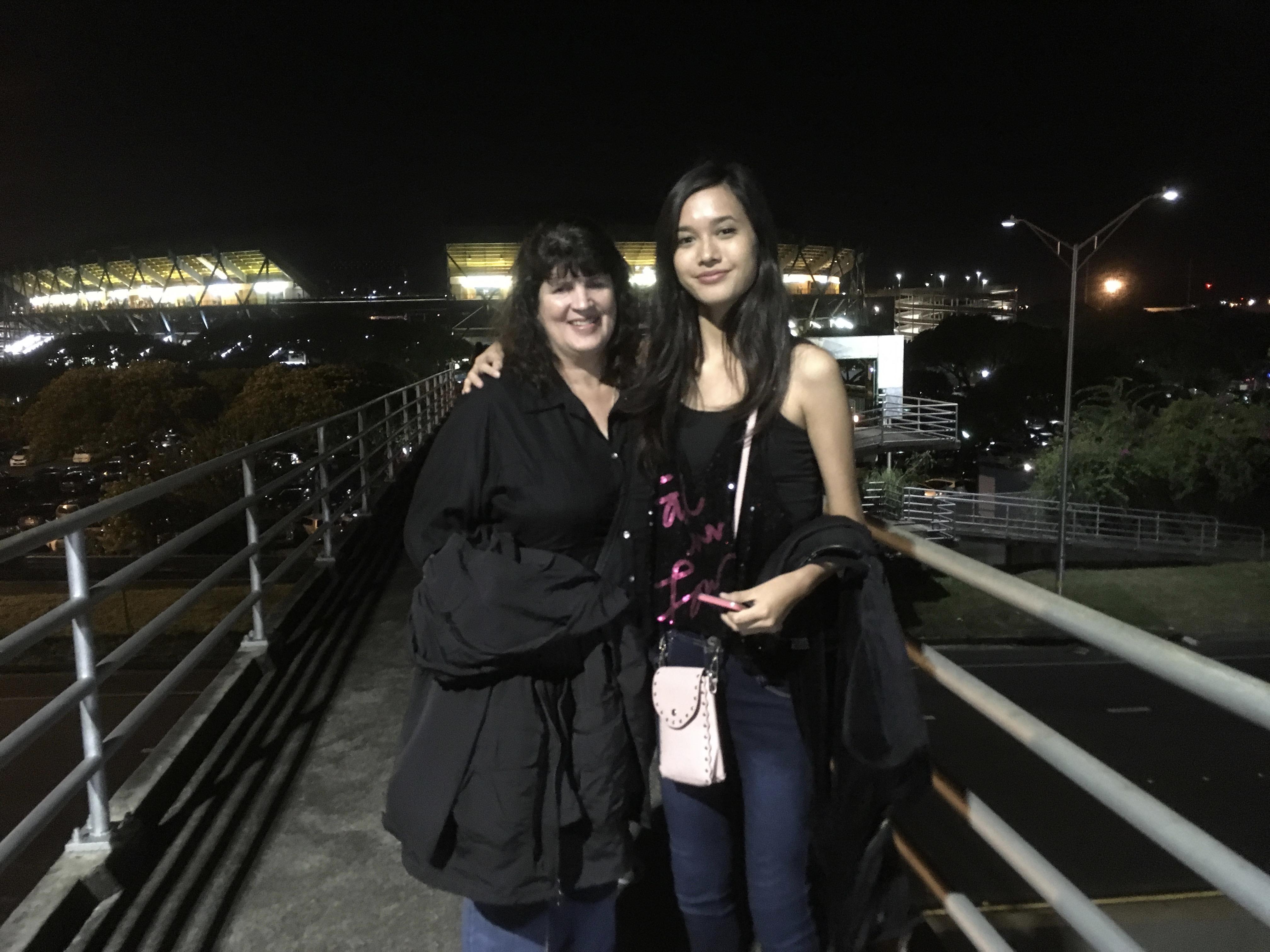 Two women standing on a bridge