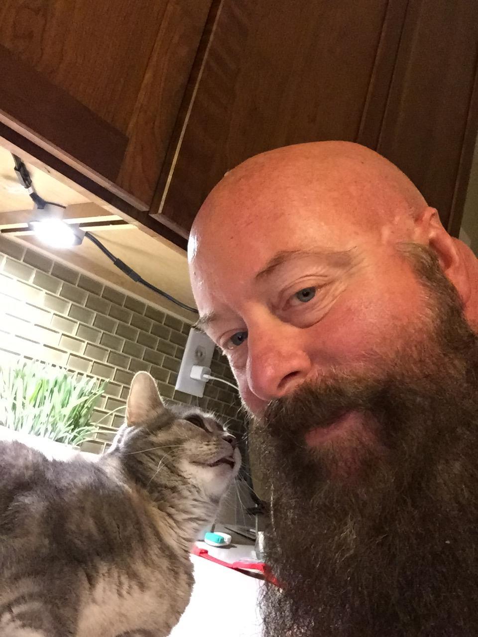 A man with a beard and a cat
