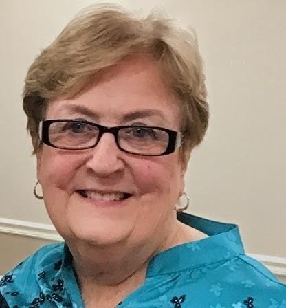 A woman wearing glasses and a blue shirt