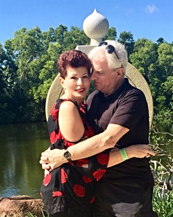 A man and woman hugging in front of water
