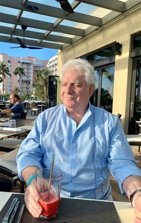A man sitting at a table with a drink