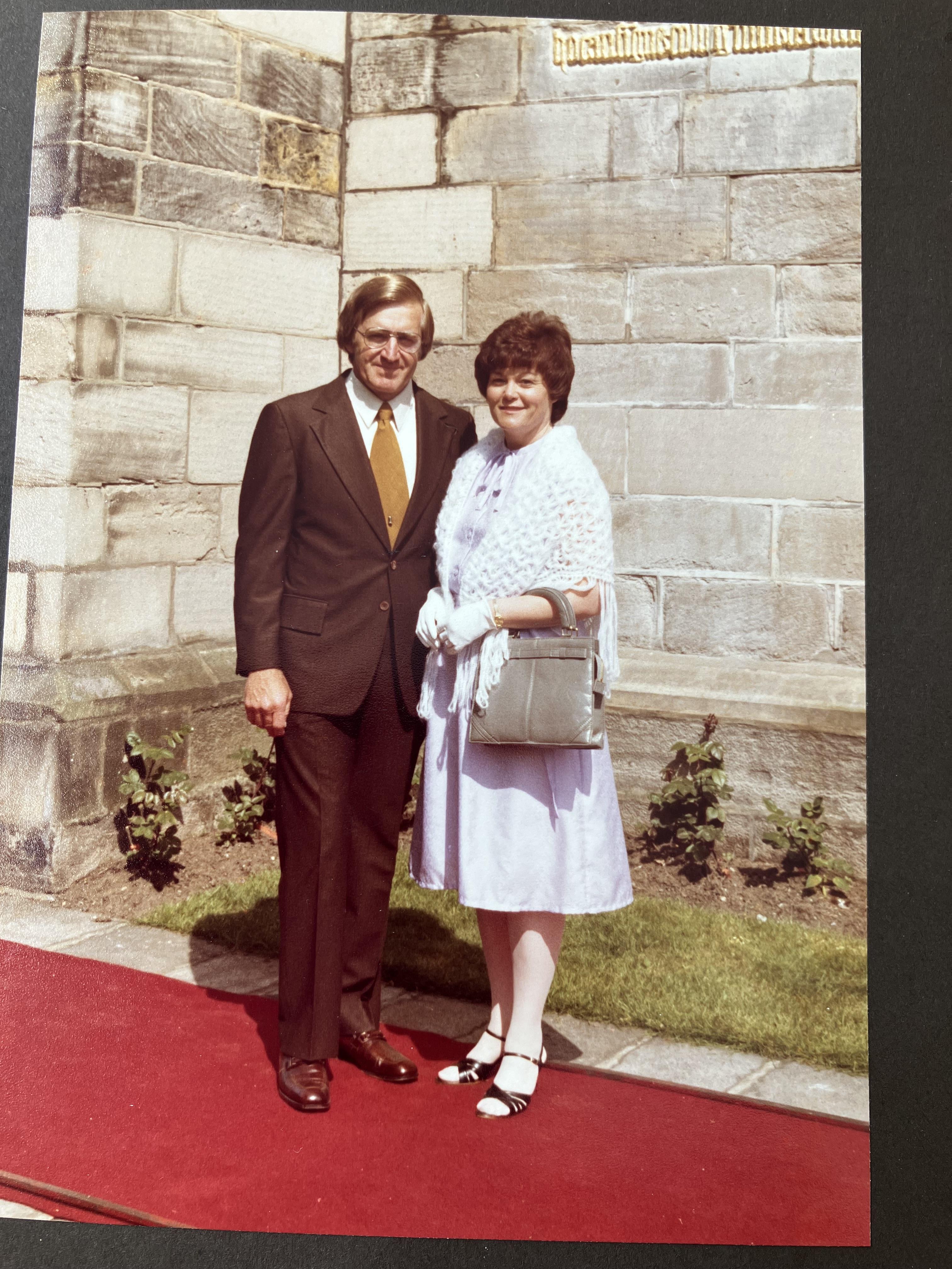 A man and woman standing on a red carpet