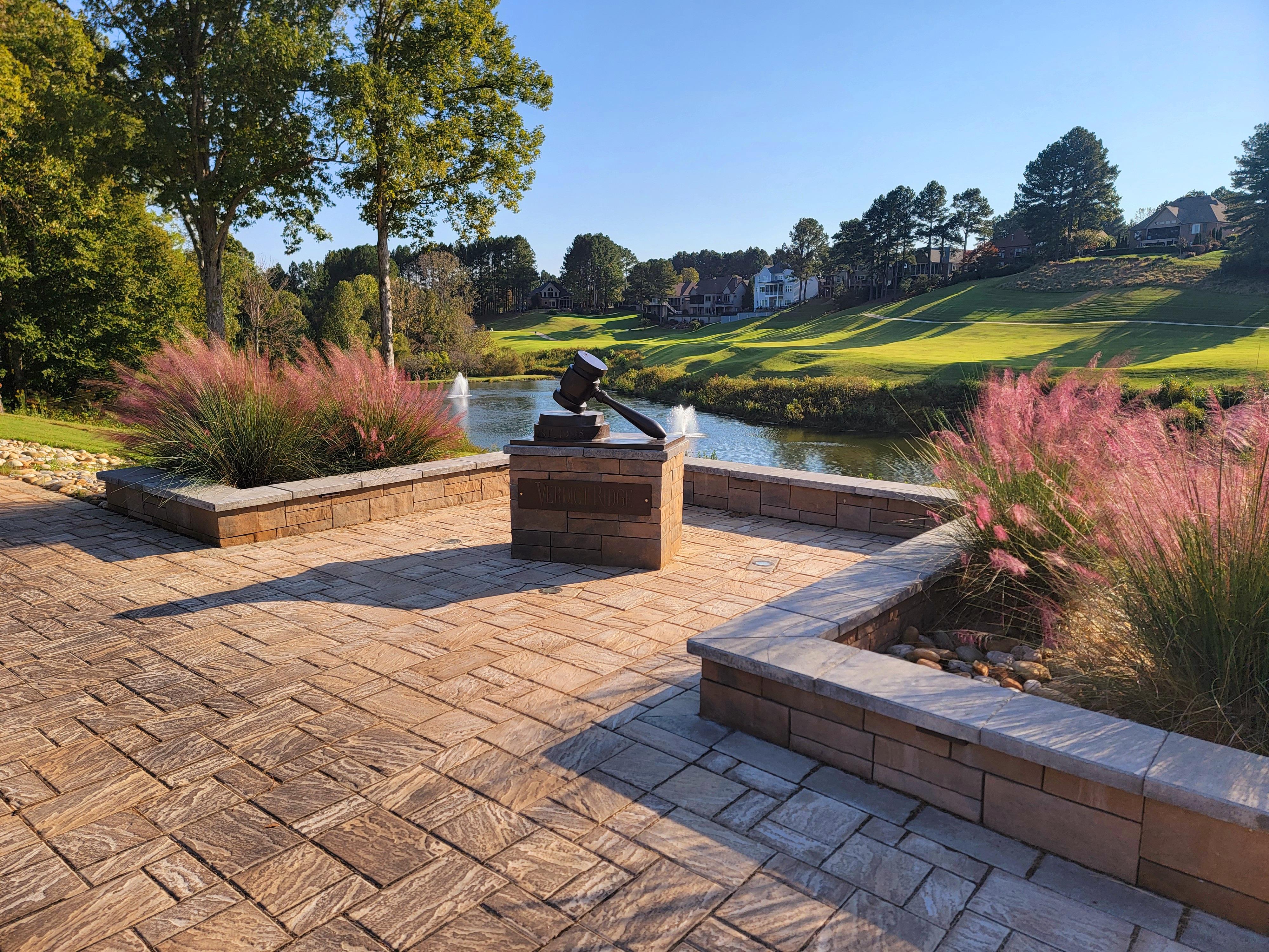 A stone patio with a fountain and a pond
