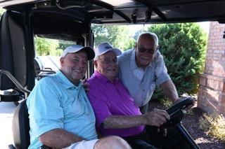 A group of men in a golf cart