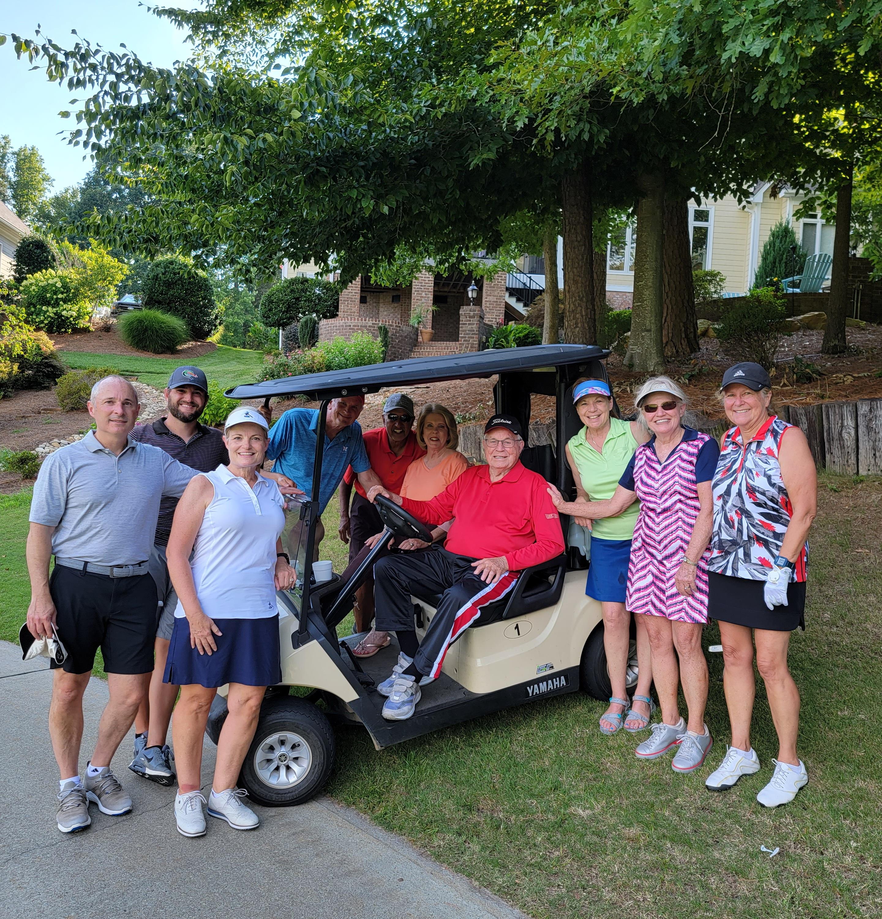 A group of people standing in a golf cart