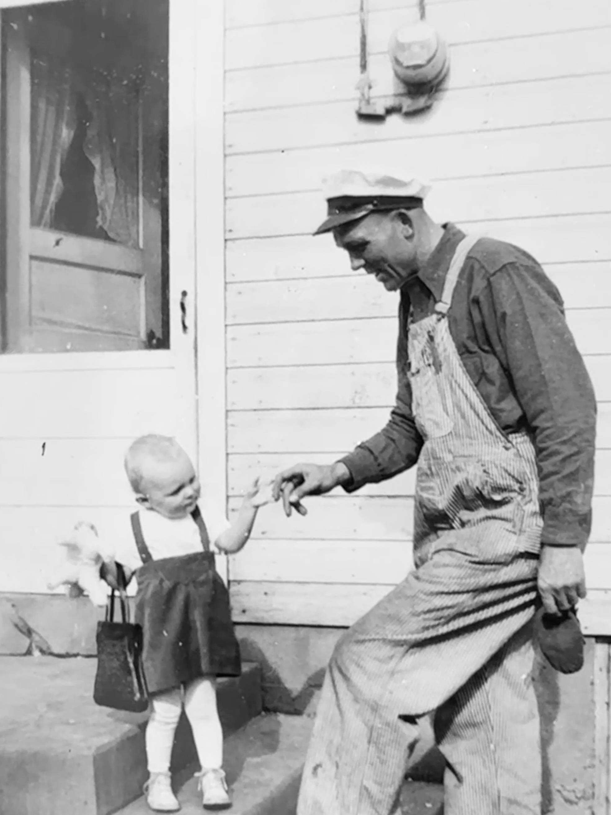 A man and baby standing outside a house