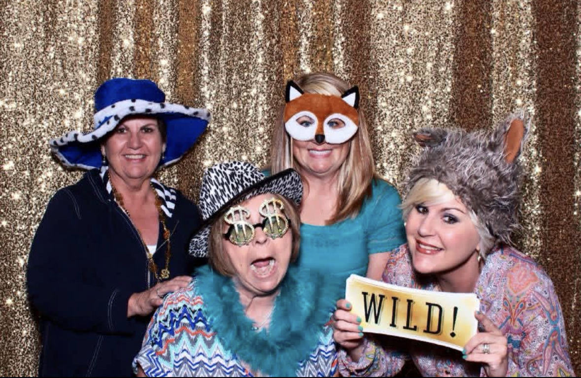 A group of women wearing hats and posing for a photo