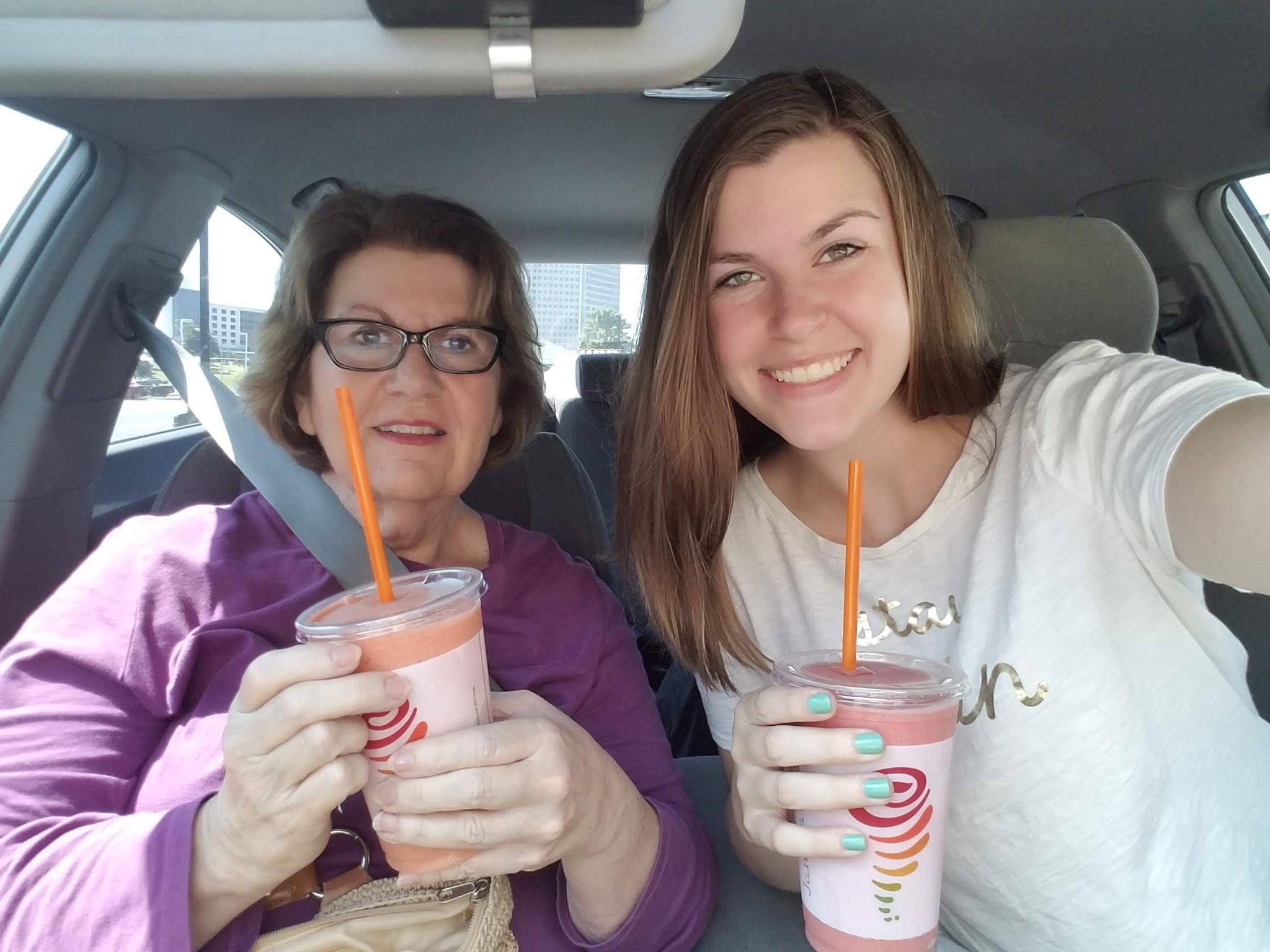 Two women in a car holding drinks