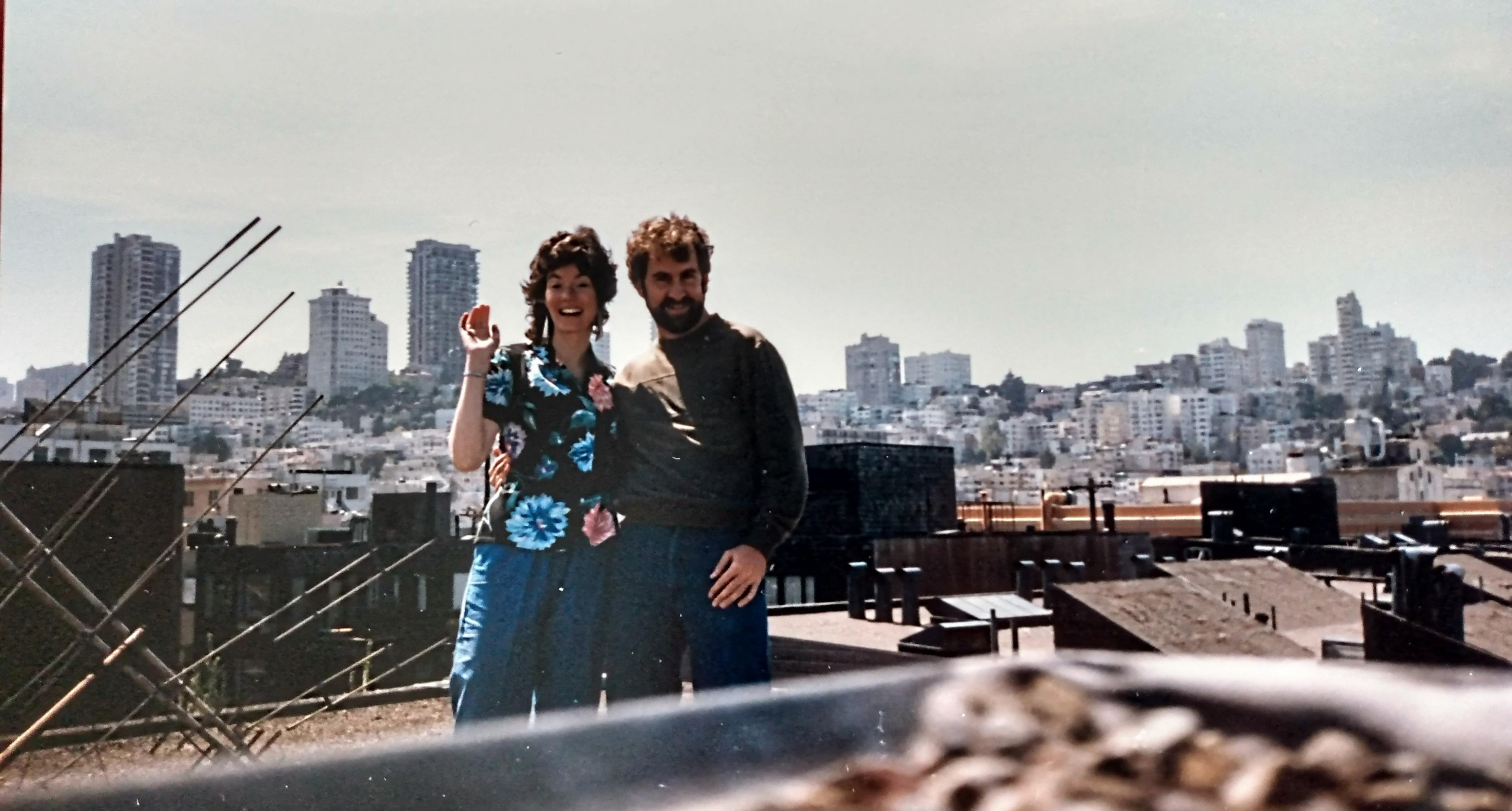 A man and woman standing on a rooftop