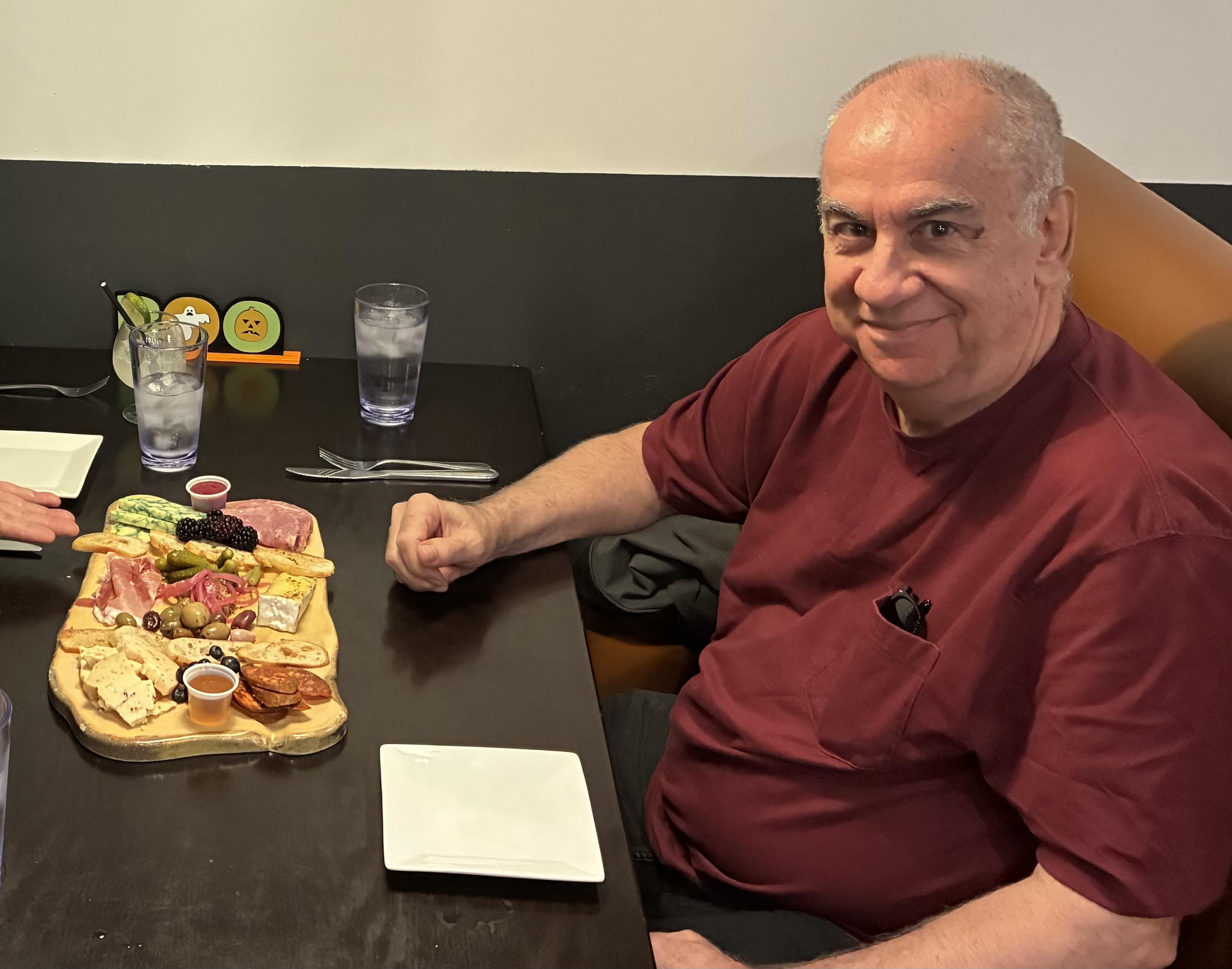 A man sitting at a table with a plate of food