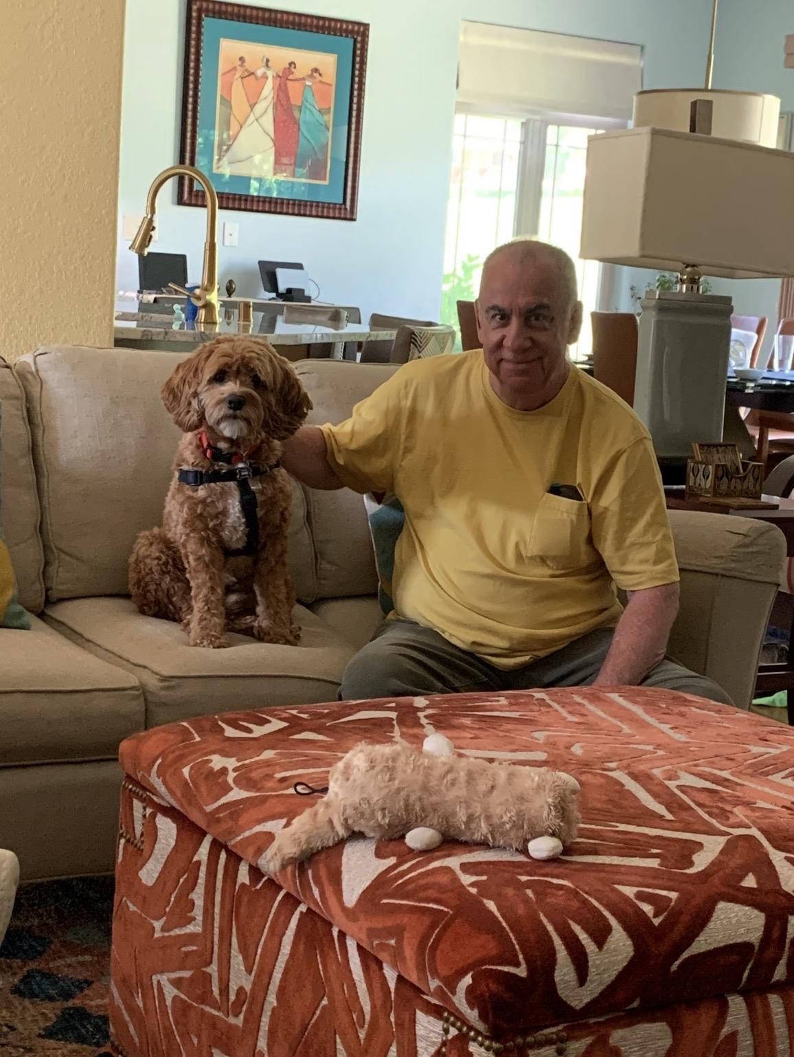 A man sitting on a couch with a dog