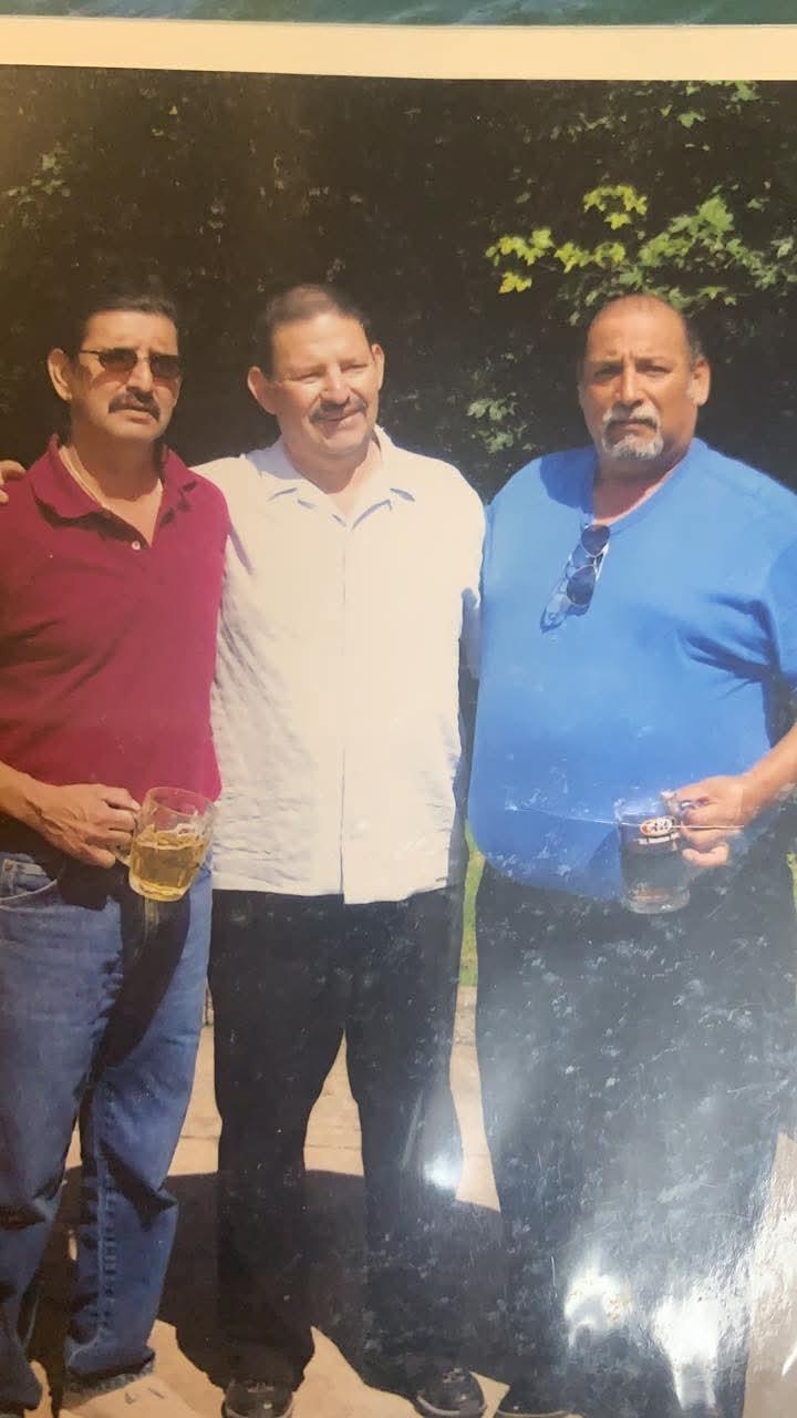 A group of men standing together holding beer glasses