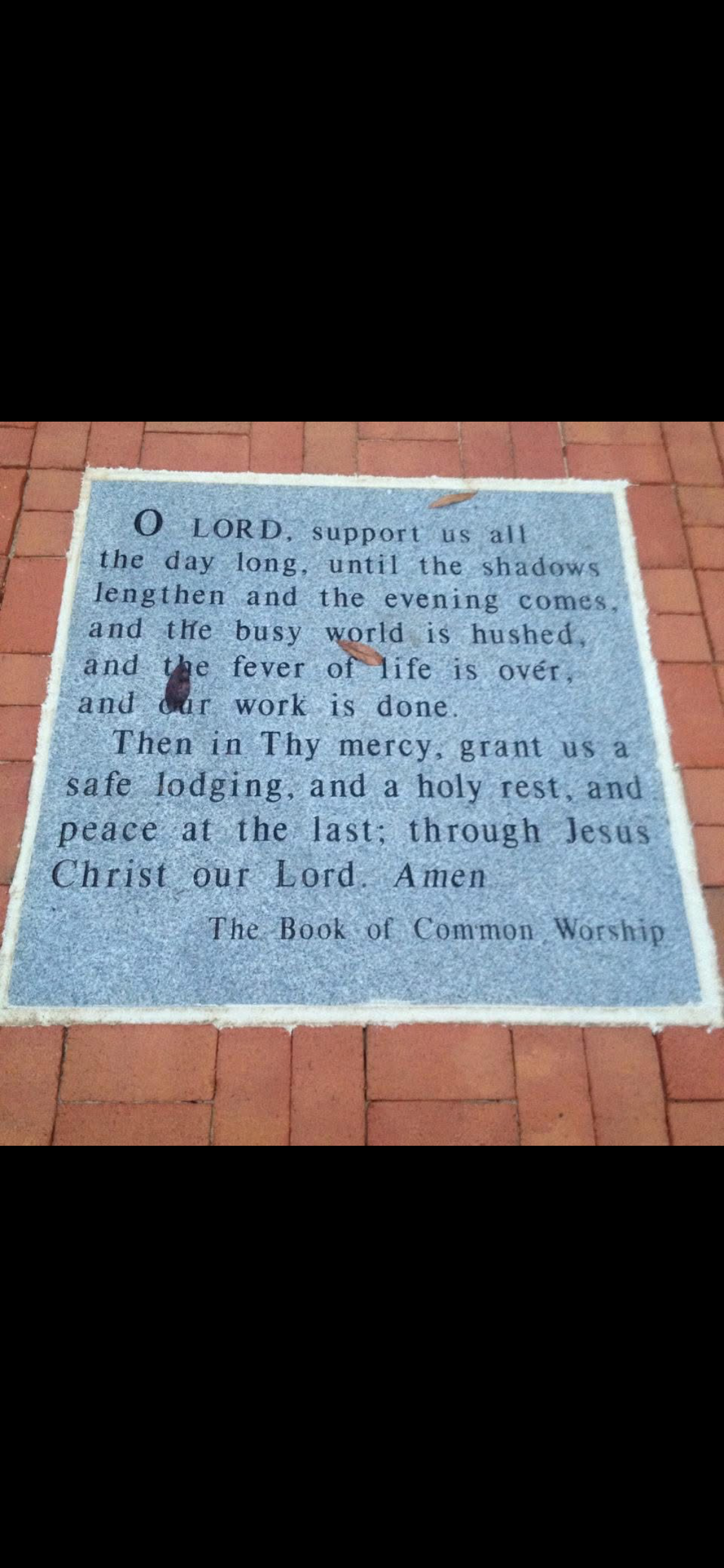 A blue sign on a brick surface