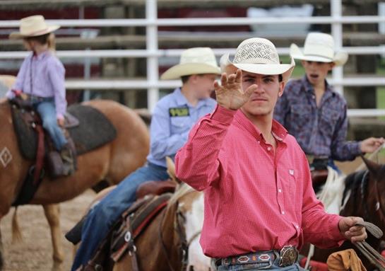 A man in cowboy hats waving