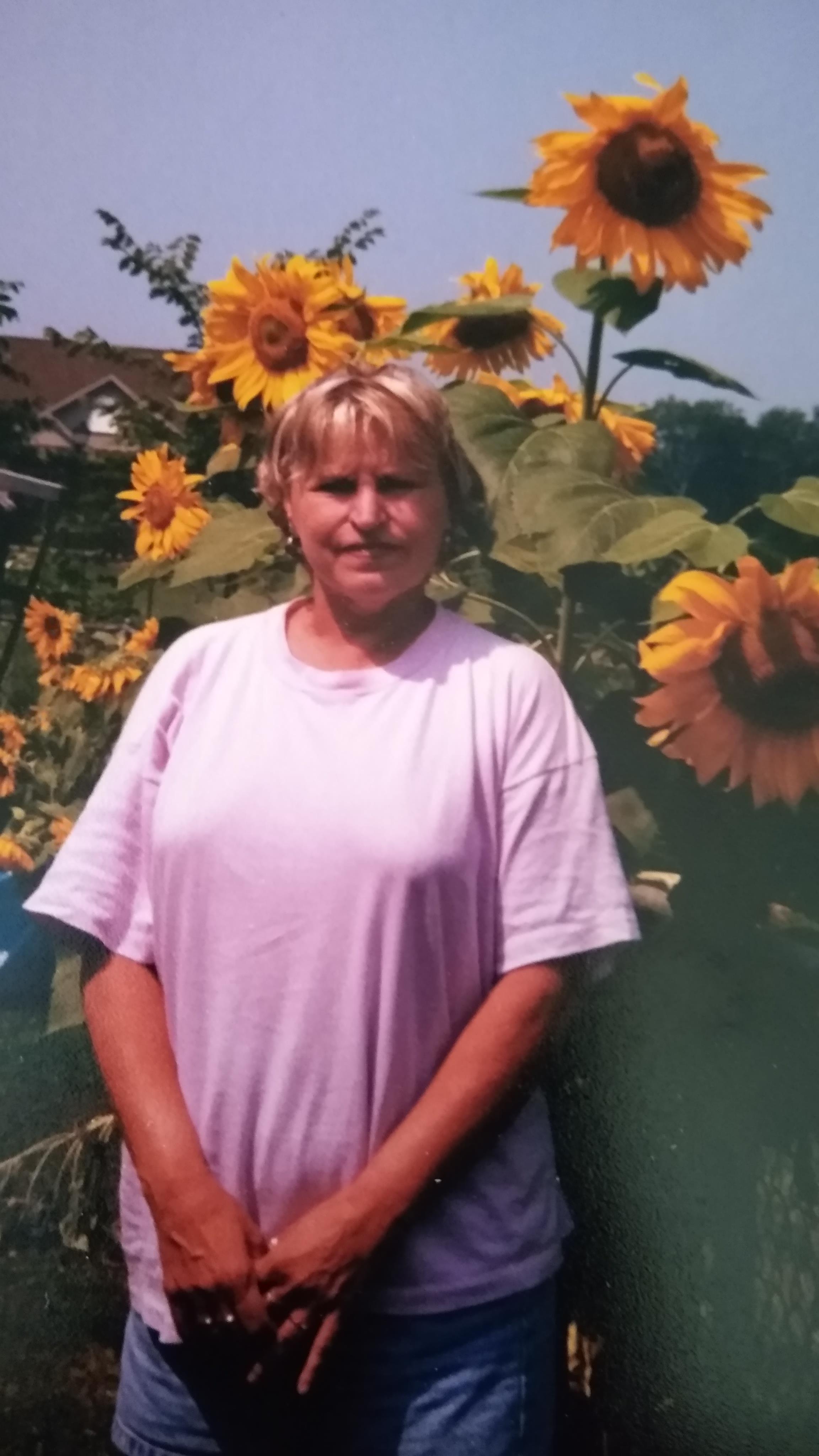 A woman standing in front of sunflowers