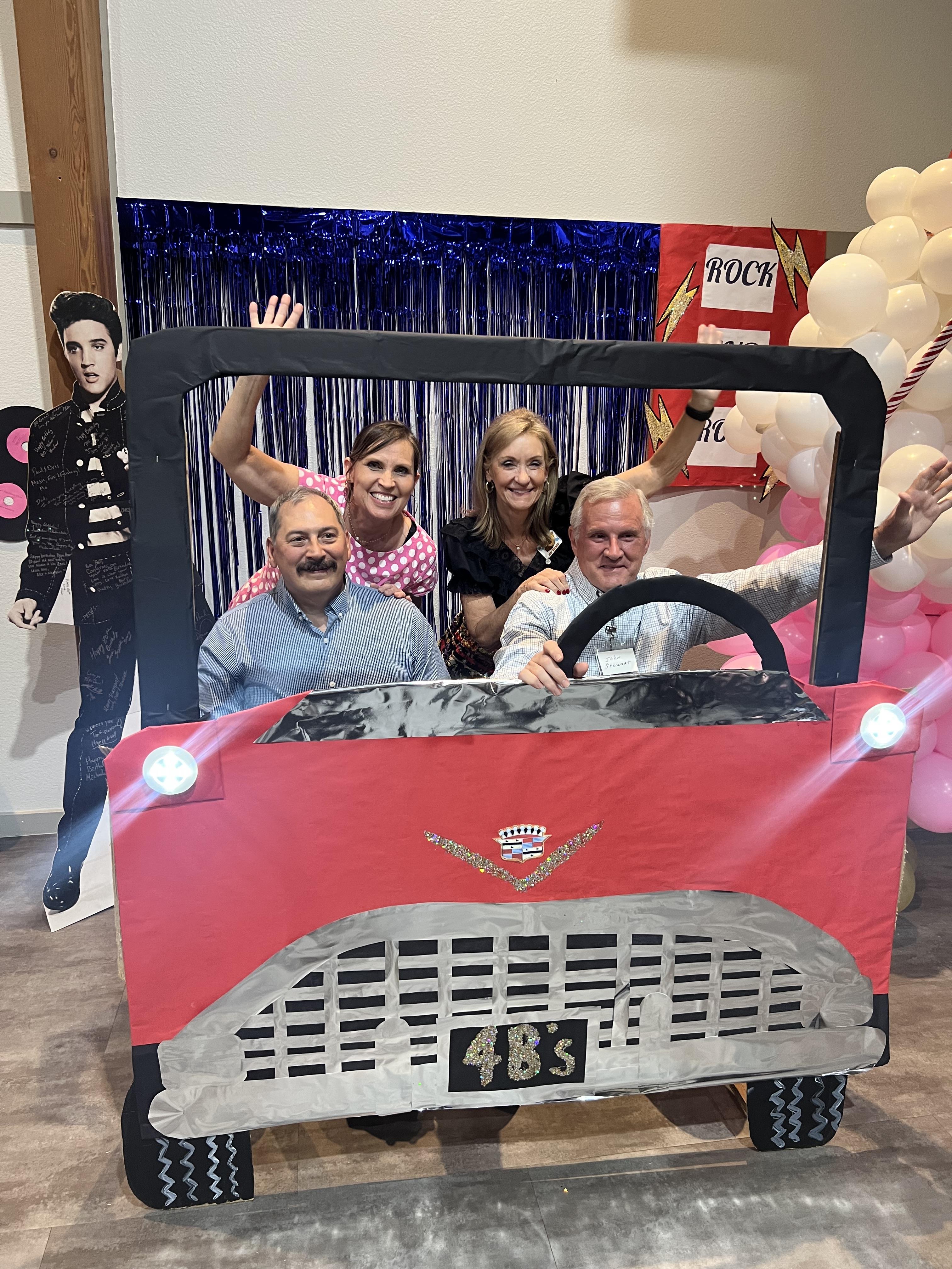 A group of people in a car shaped cardboard