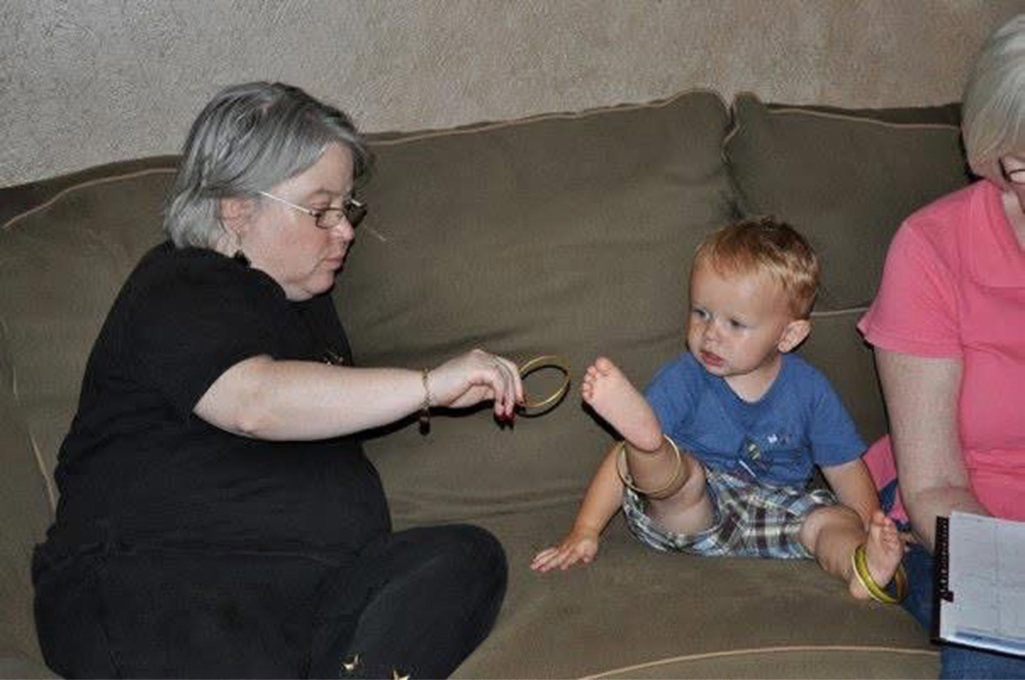 A woman and a baby sitting on a couch