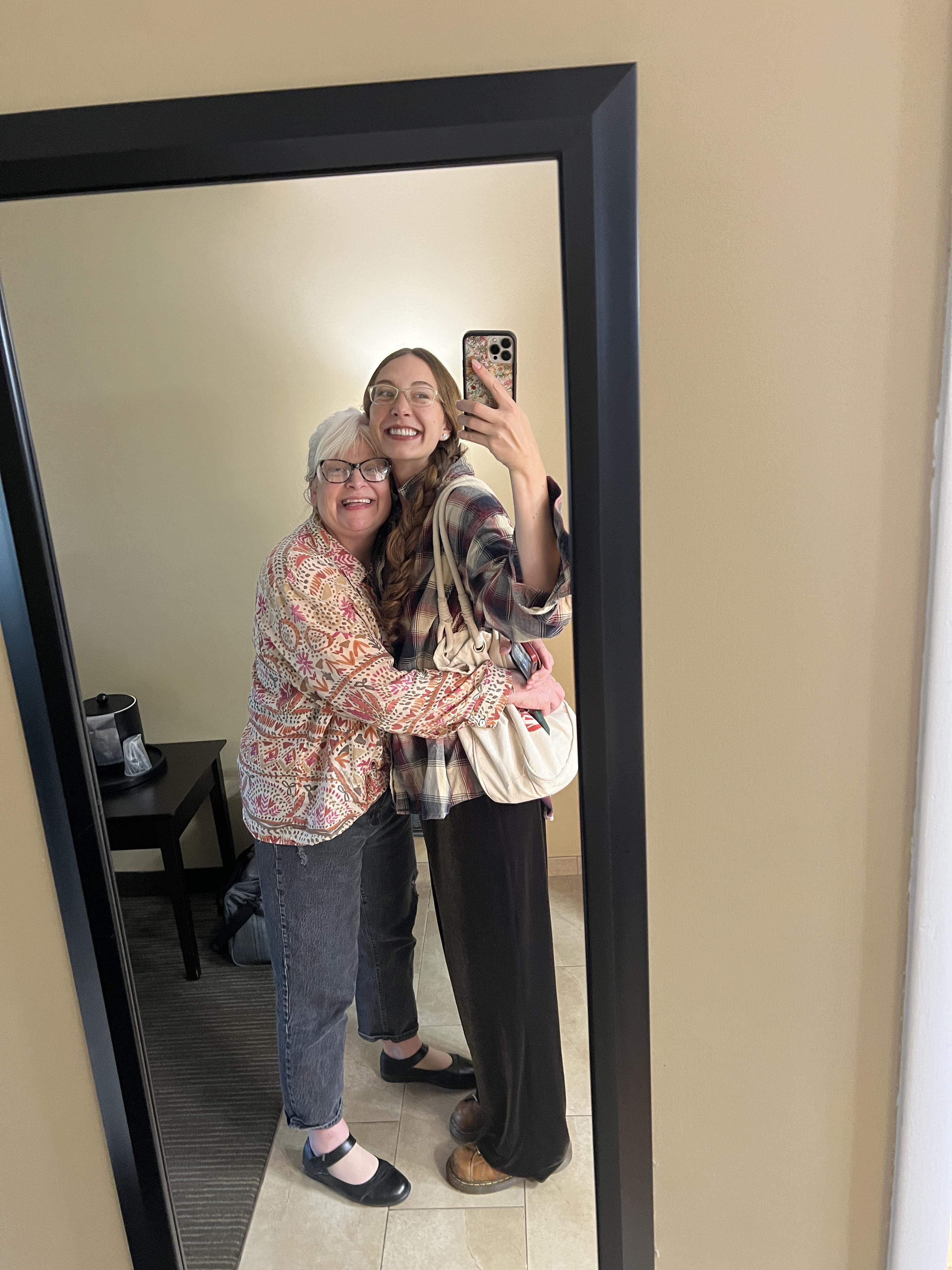 Two women taking a selfie in a mirror