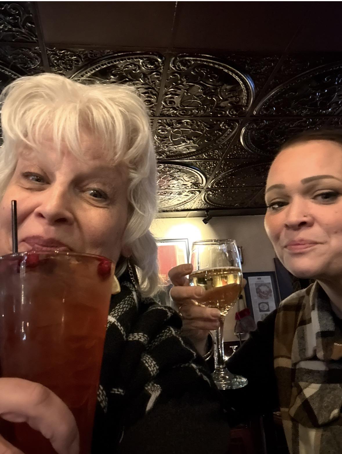 Two women holding drinks and smiling