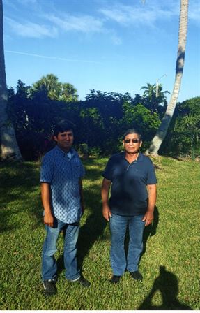 Two men standing in a grassy area