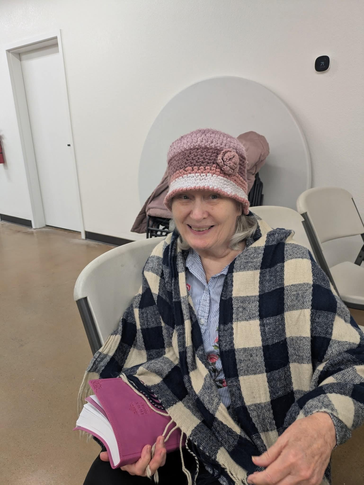 A woman wearing a hat and blanket
