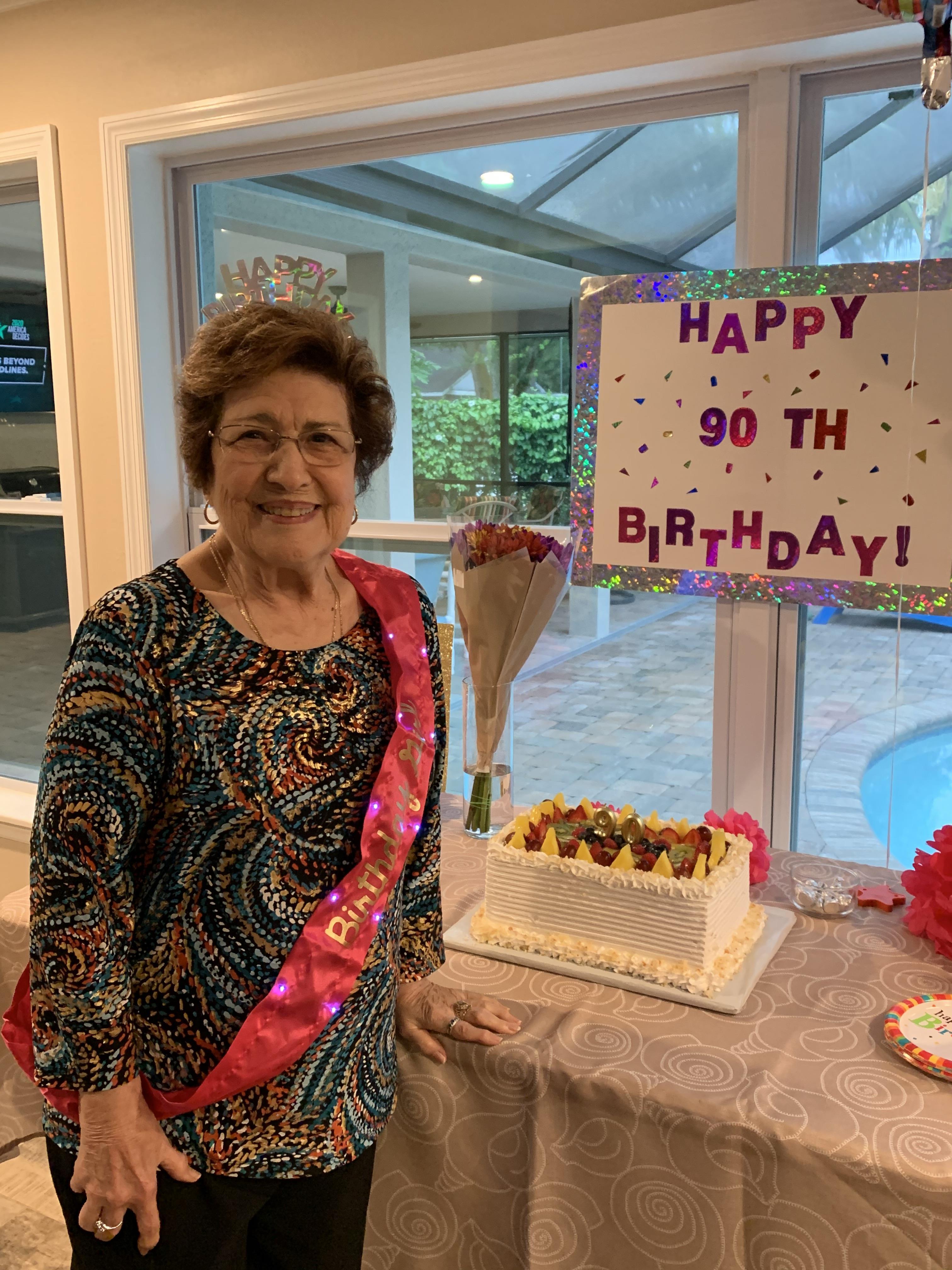 A woman standing next to a cake