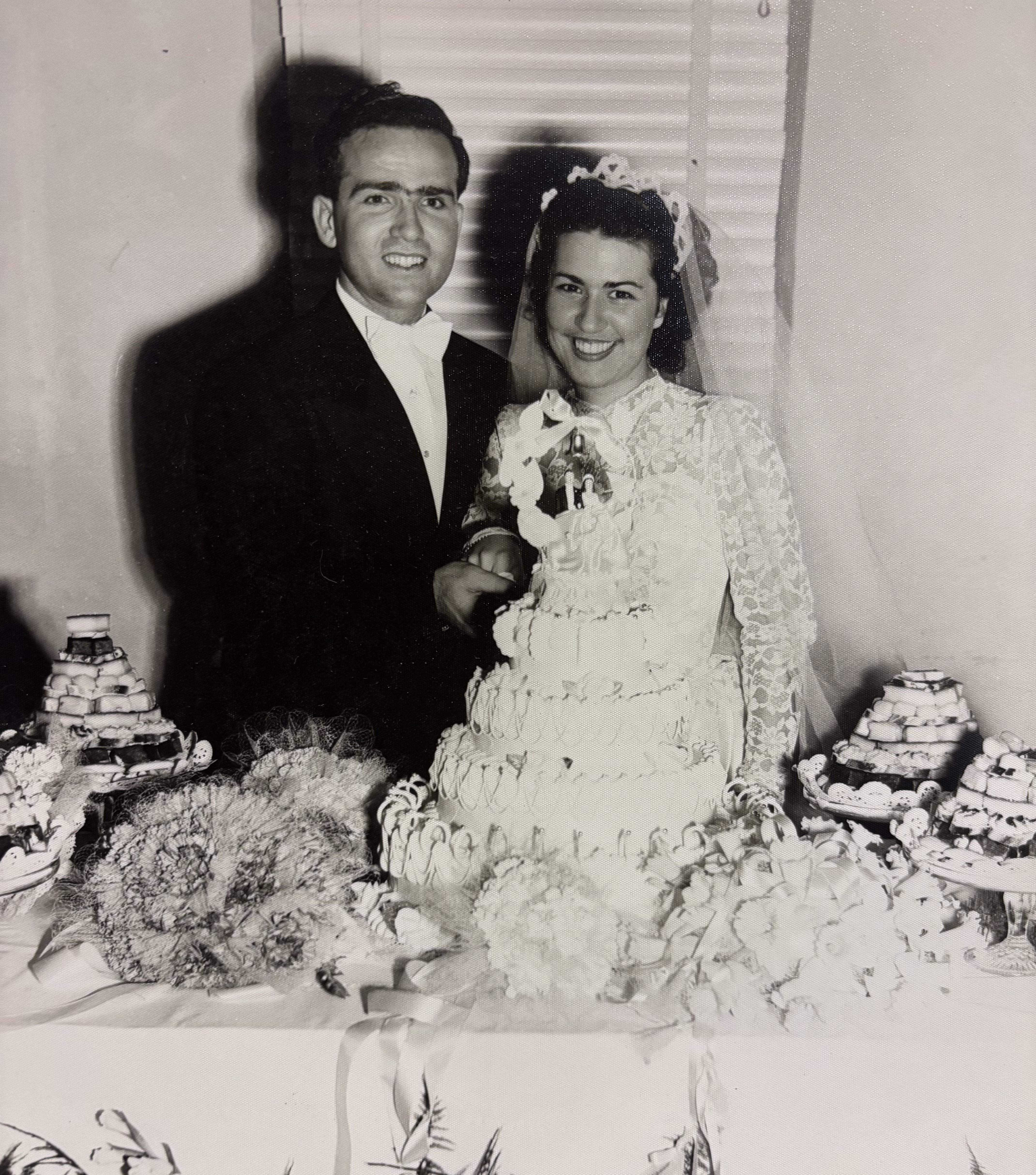 A man and woman standing next to a cake